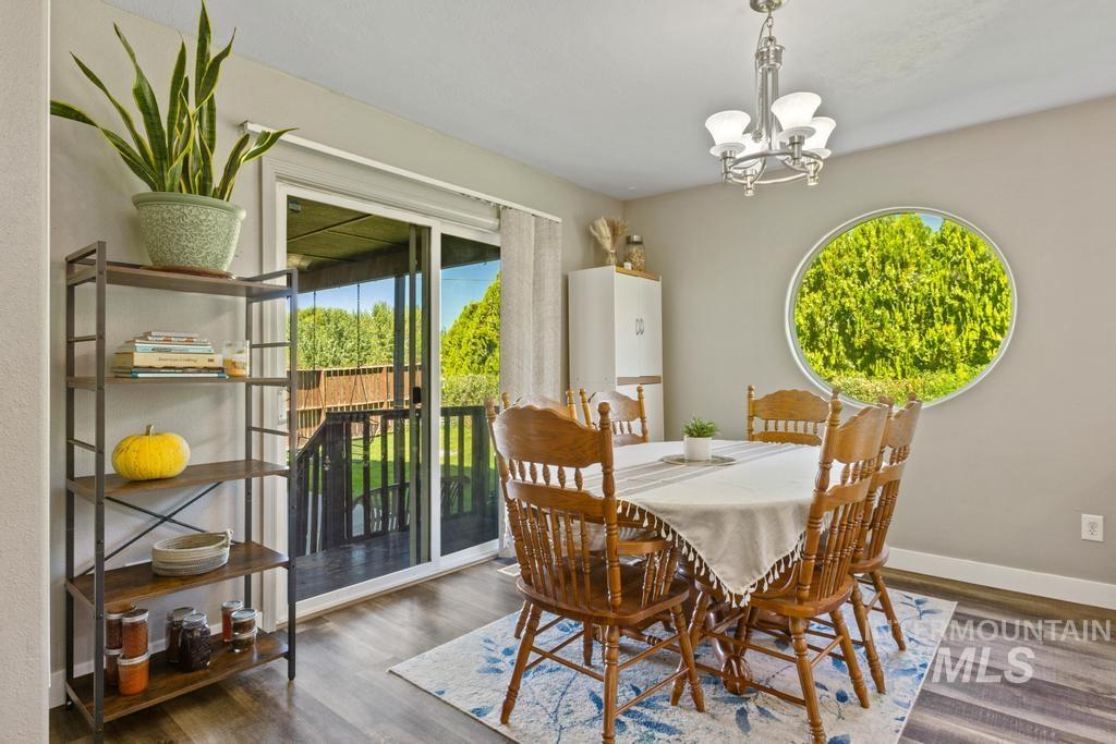 Dining area featuring dark wood-type flooring, plenty of natural light, and a chandelier