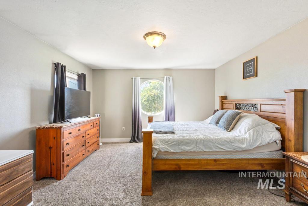 Bedroom with light colored carpet and baseboards