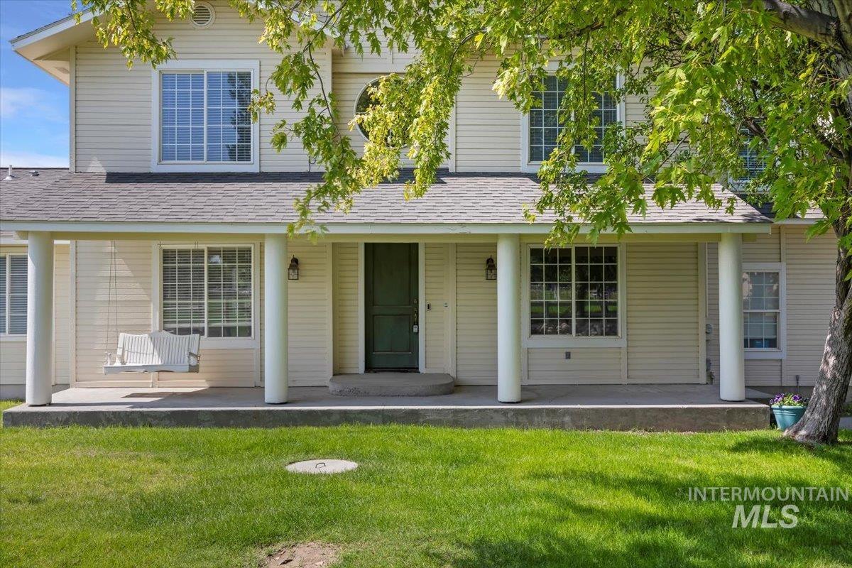 View of front of home featuring roof with shingles, a front yard, and covered porch