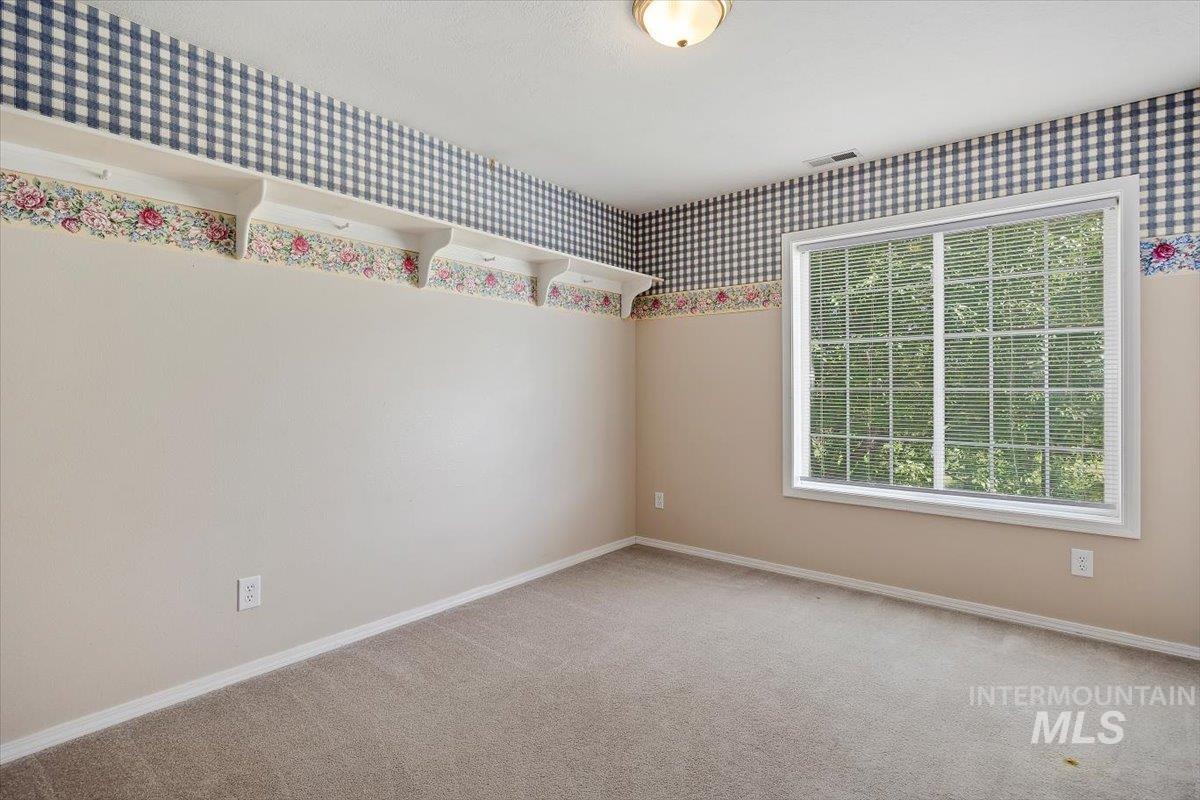 Carpeted spare room with baseboards