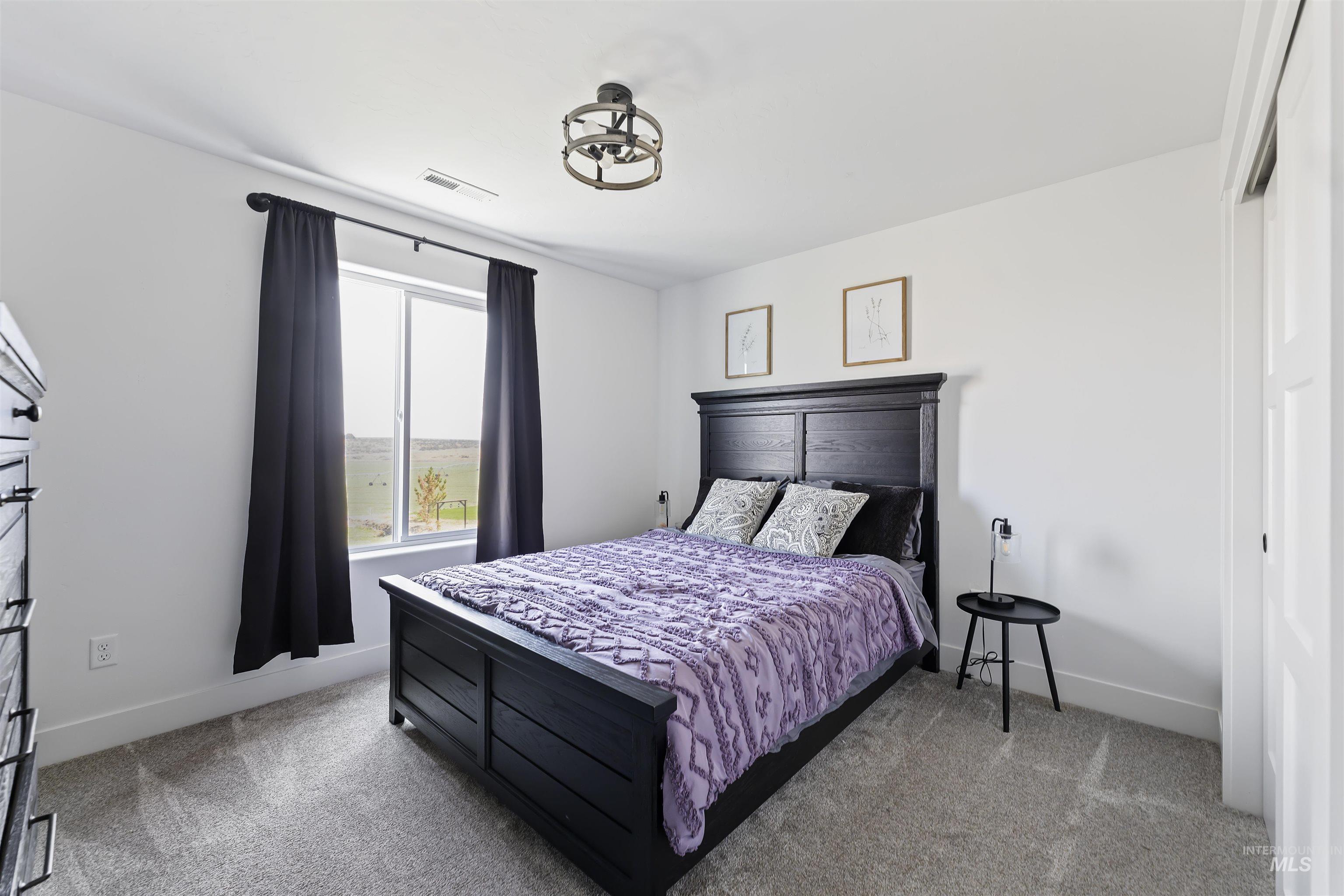 Bedroom featuring light colored carpet and baseboards
