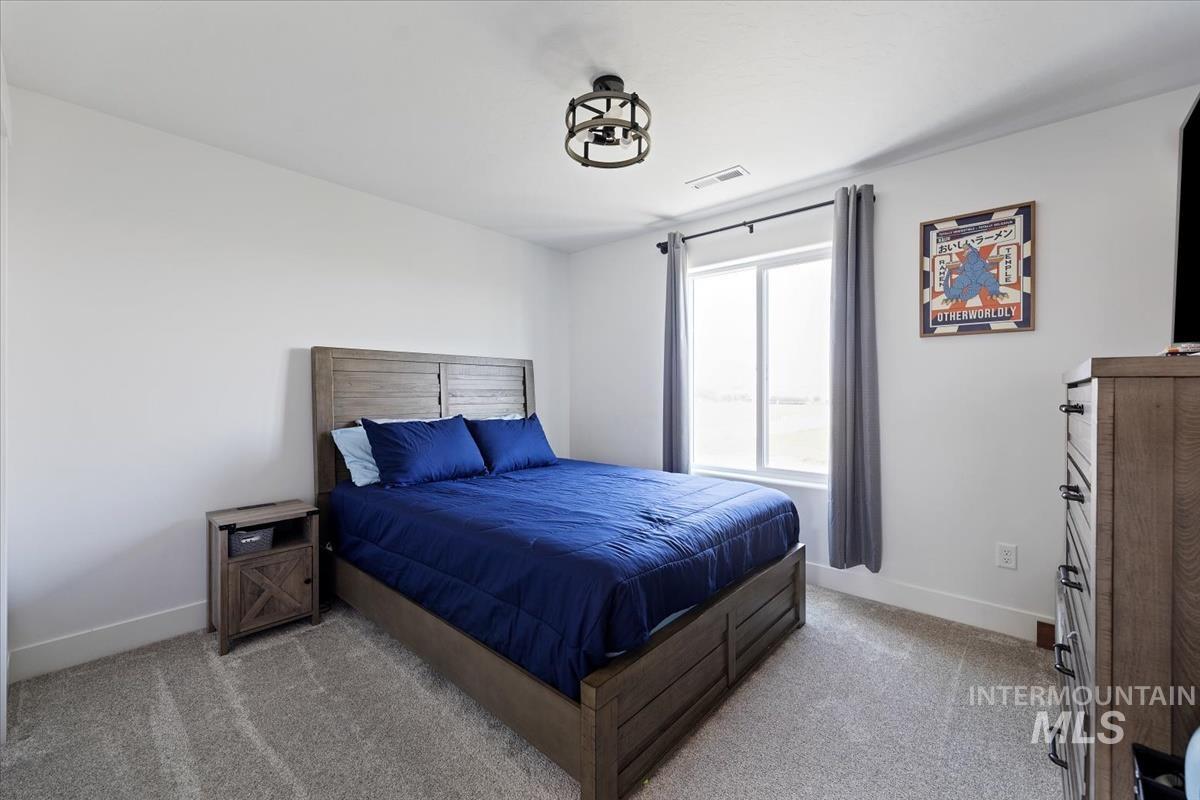 Bedroom with light colored carpet and baseboards
