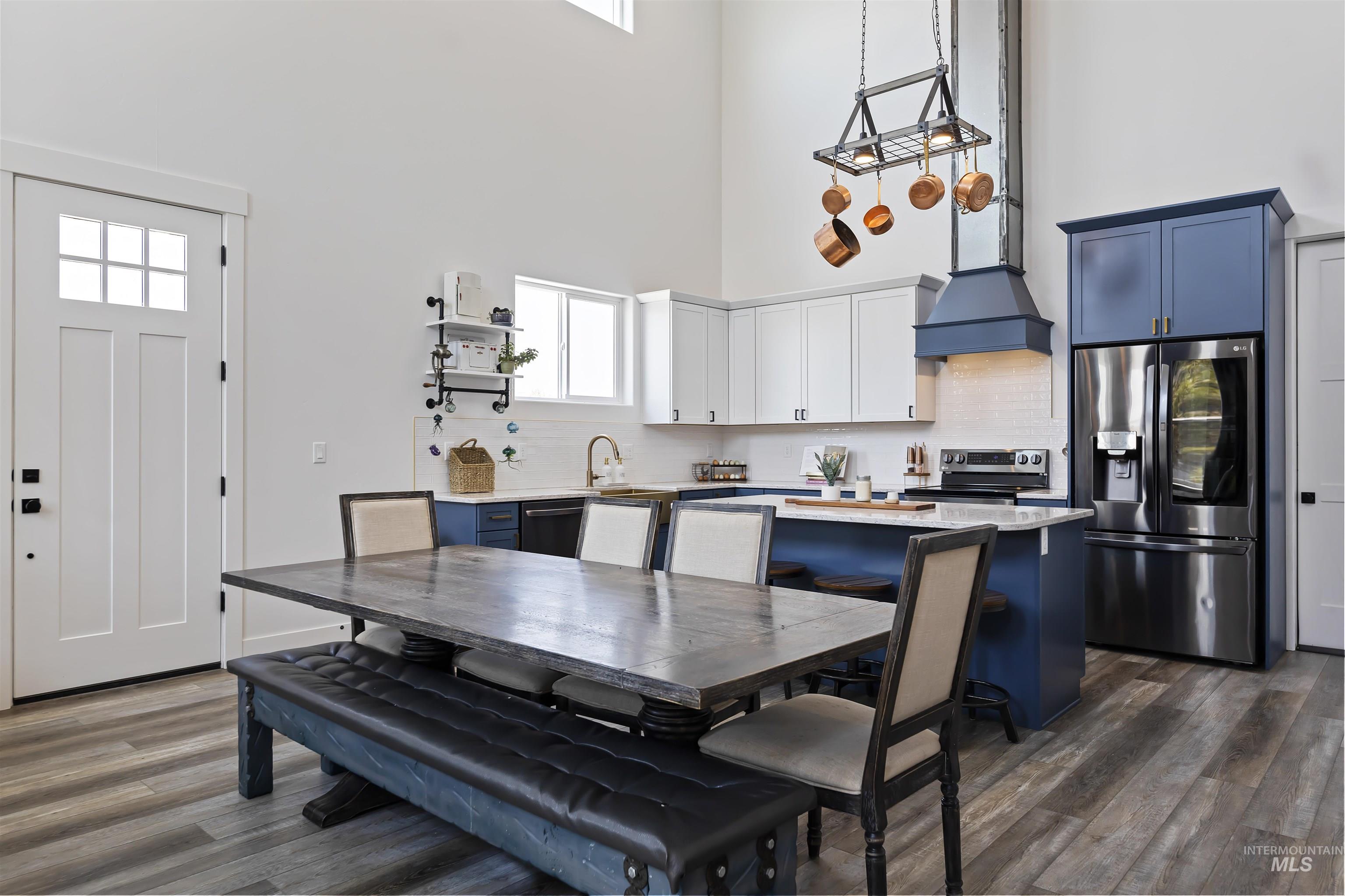 Dining room with dark wood-type flooring and a high ceiling