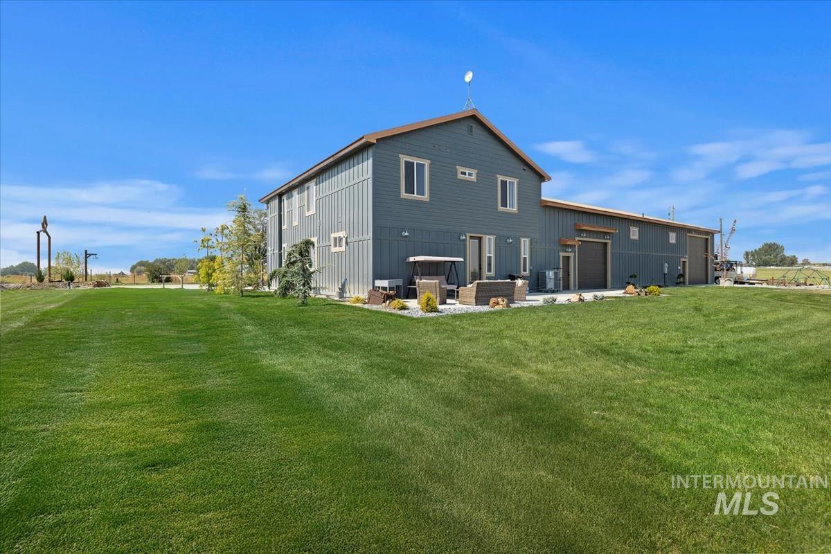 Back of house with a patio, a lawn, and board and batten siding