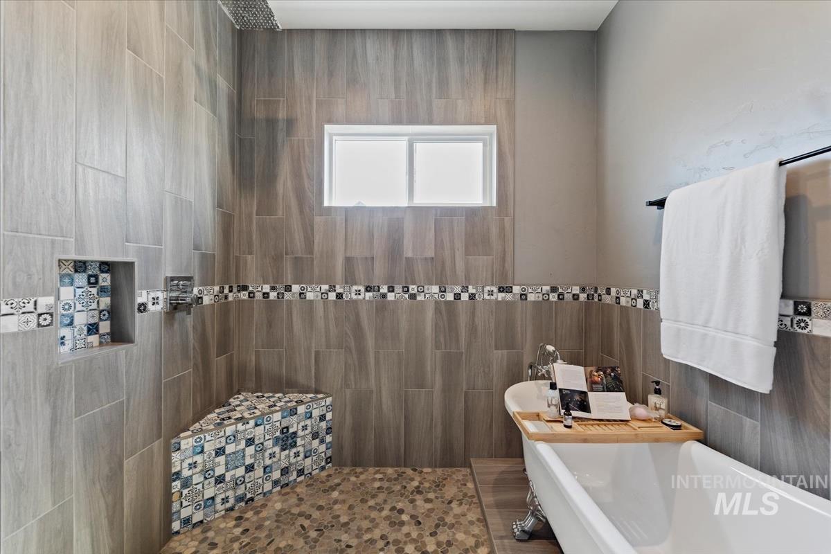 Full bath with a freestanding tub, tile walls, and a tile shower