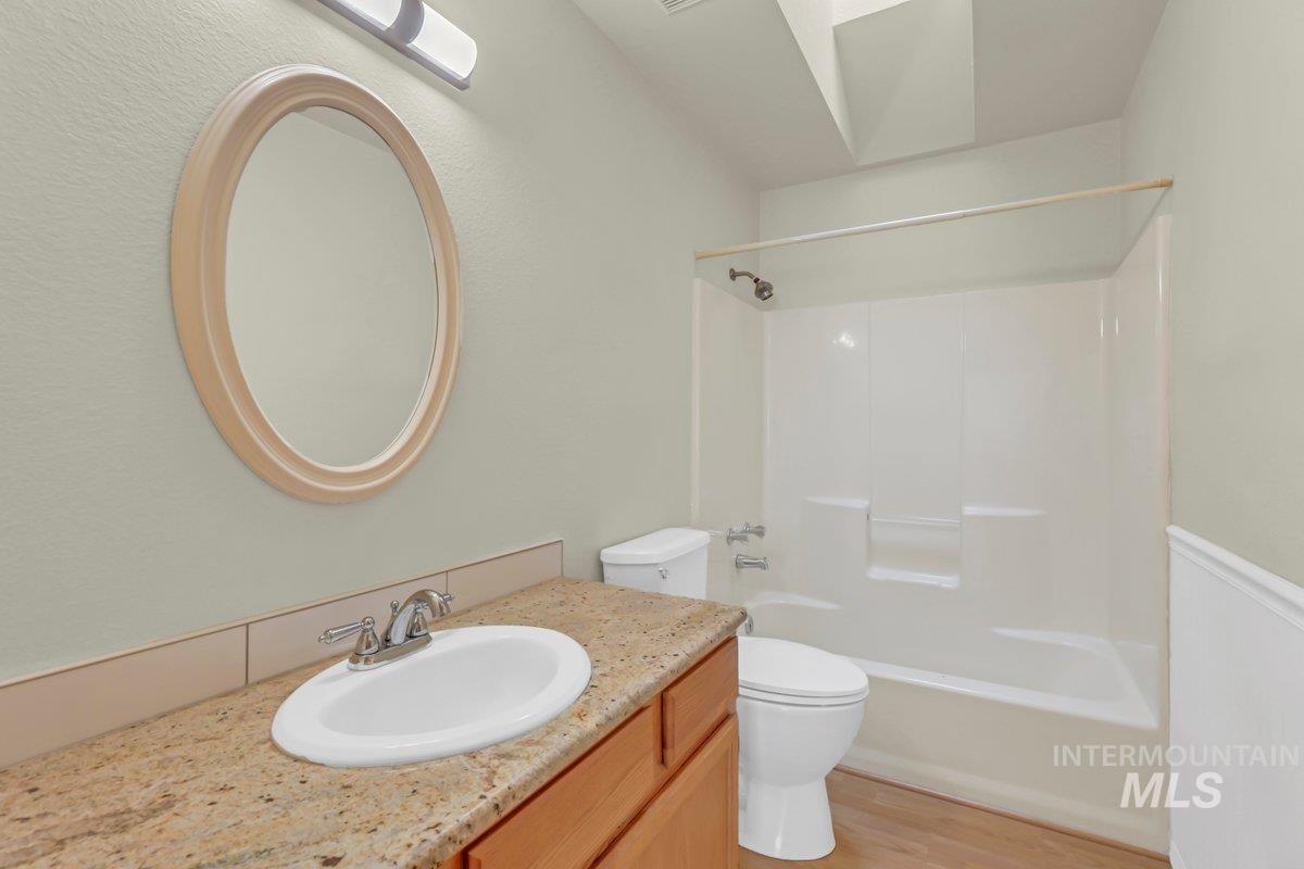 Full bath with shower / washtub combination, light wood-style floors, and vanity