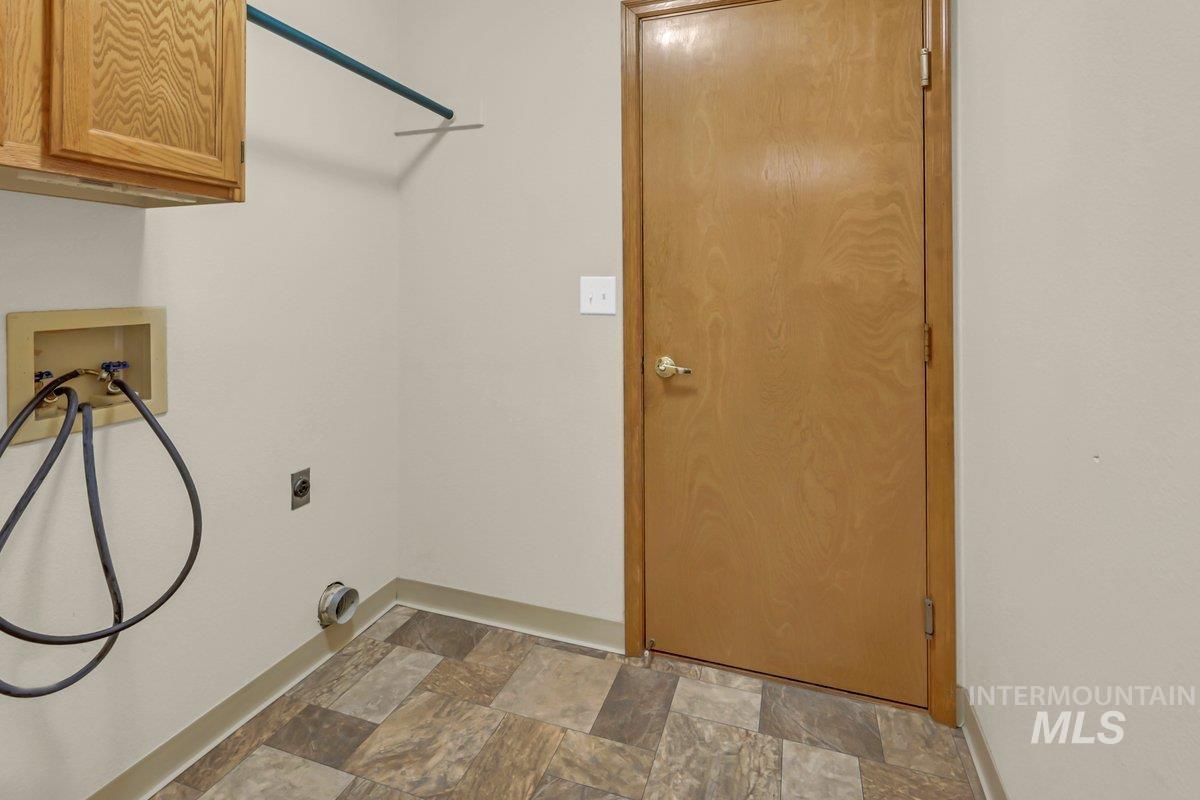 Laundry room featuring stone finish flooring, cabinet space, washer hookup, and electric dryer hookup