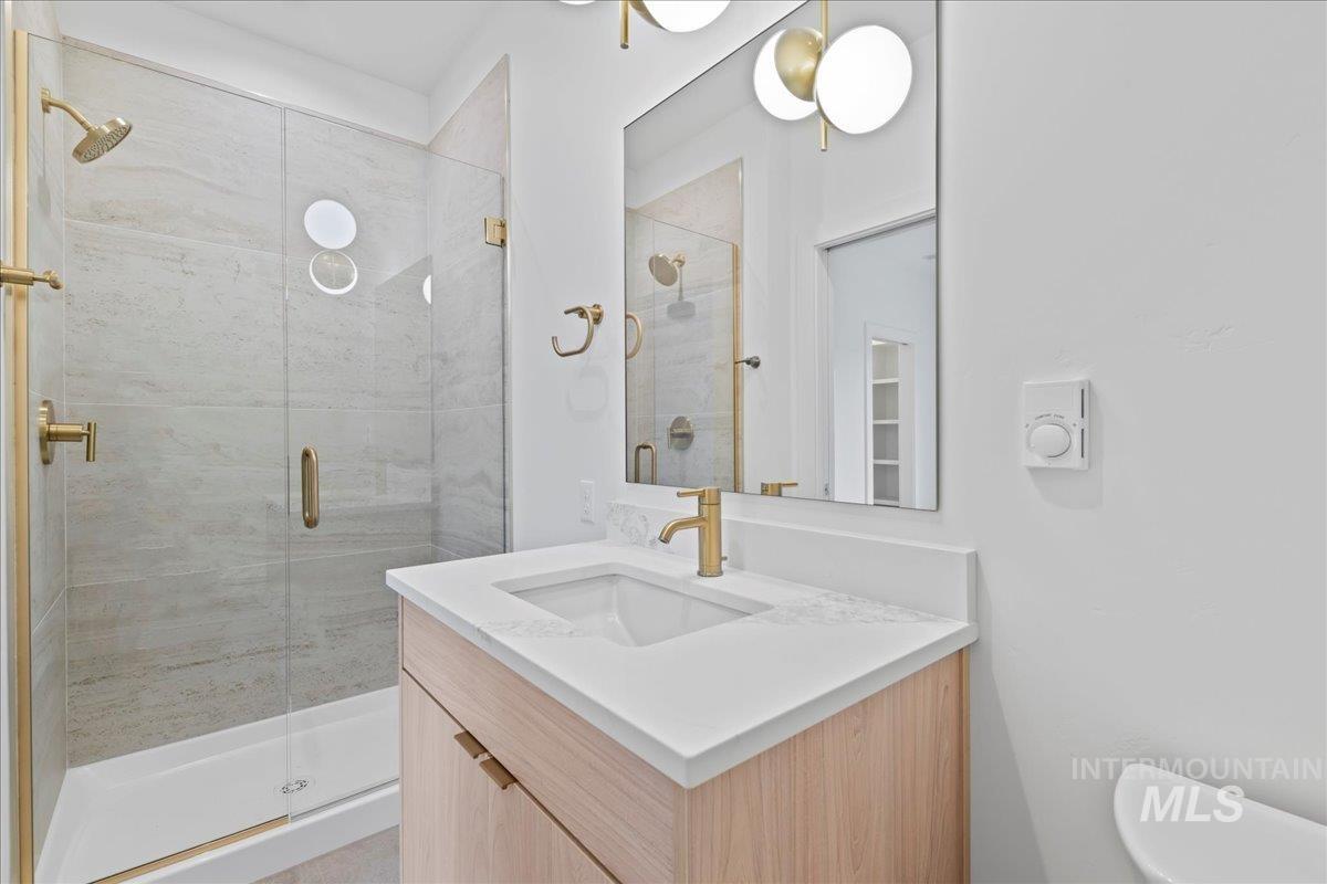 Full bathroom with vanity and a shower stall
