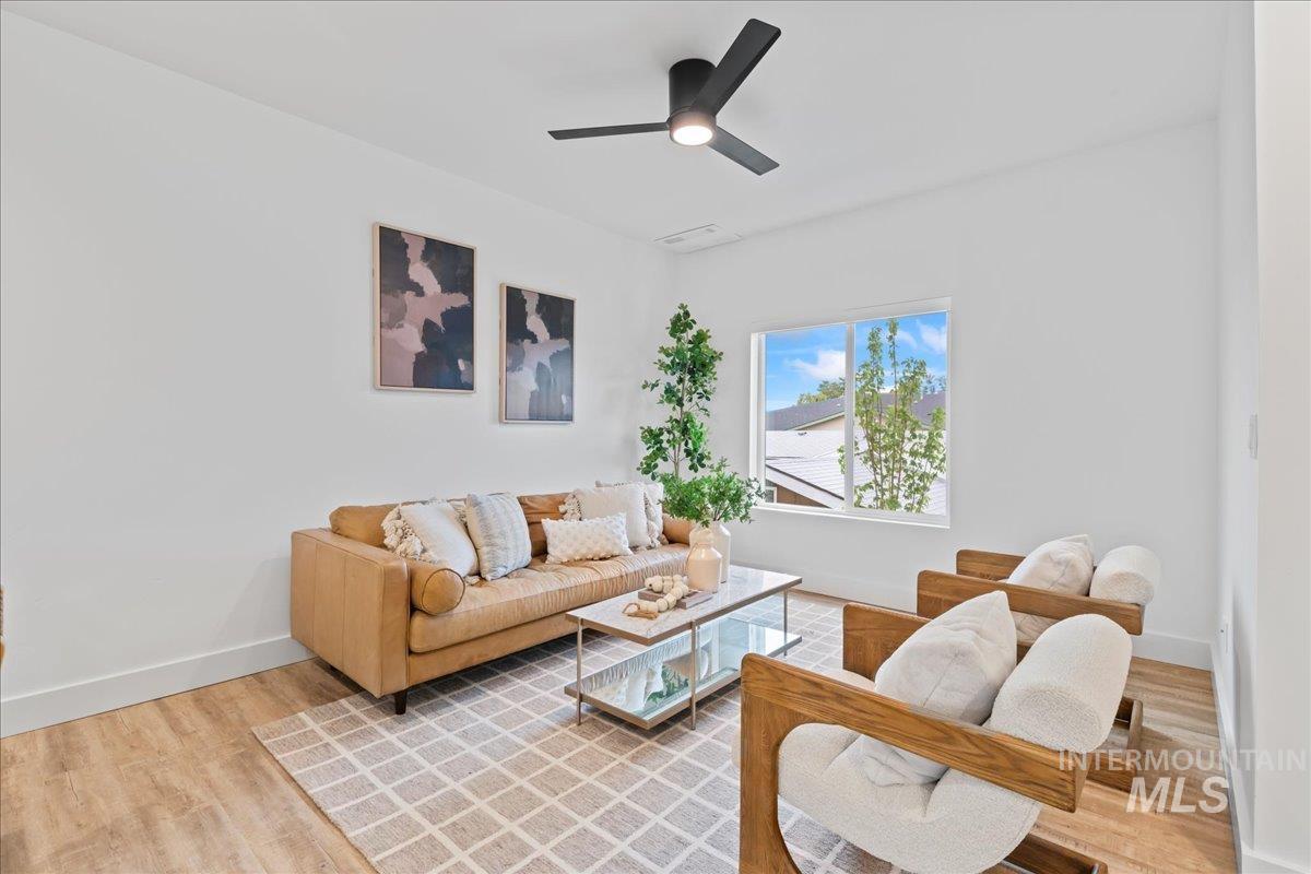 Living room featuring light wood finished floors and a ceiling fan