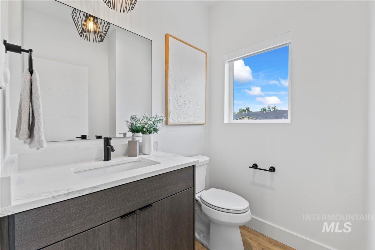 Half bathroom featuring vanity and light wood-style flooring