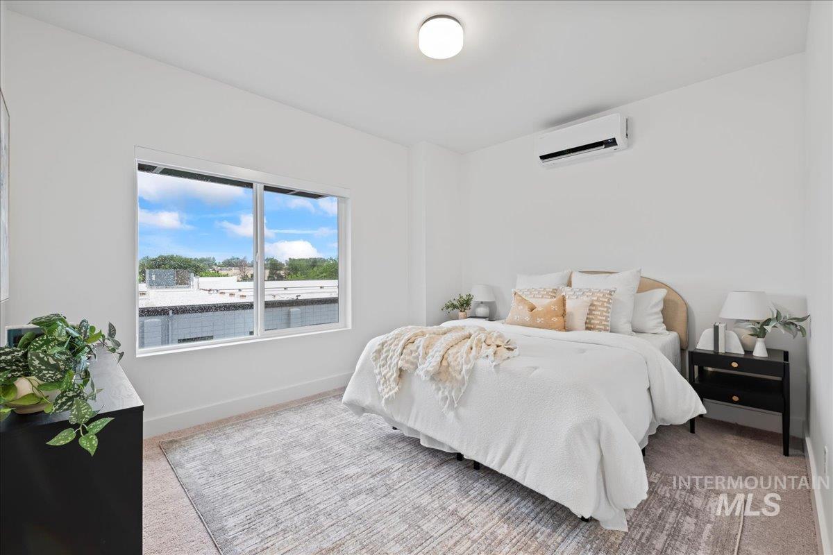 Bedroom featuring carpet flooring and a wall unit AC