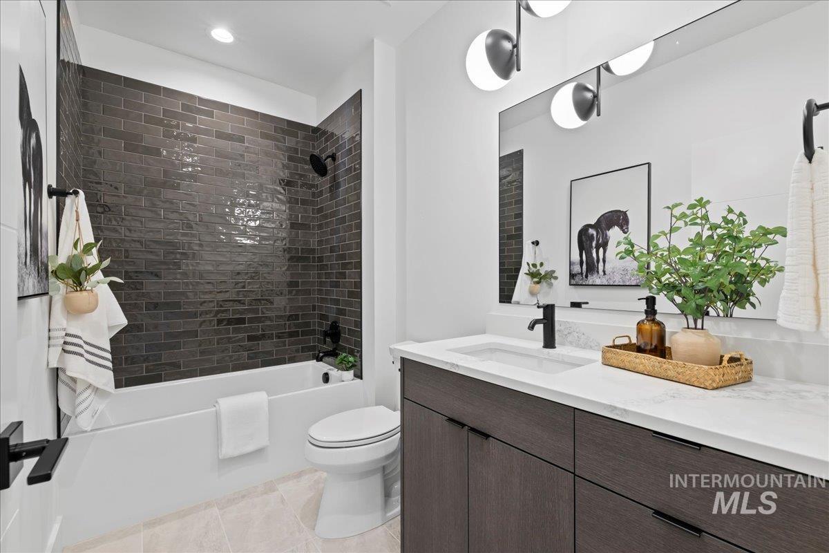 Bathroom featuring  shower combination, vanity, light tile patterned floors, and recessed lighting