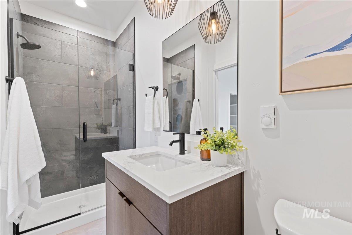 Full bathroom with vanity and a shower stall