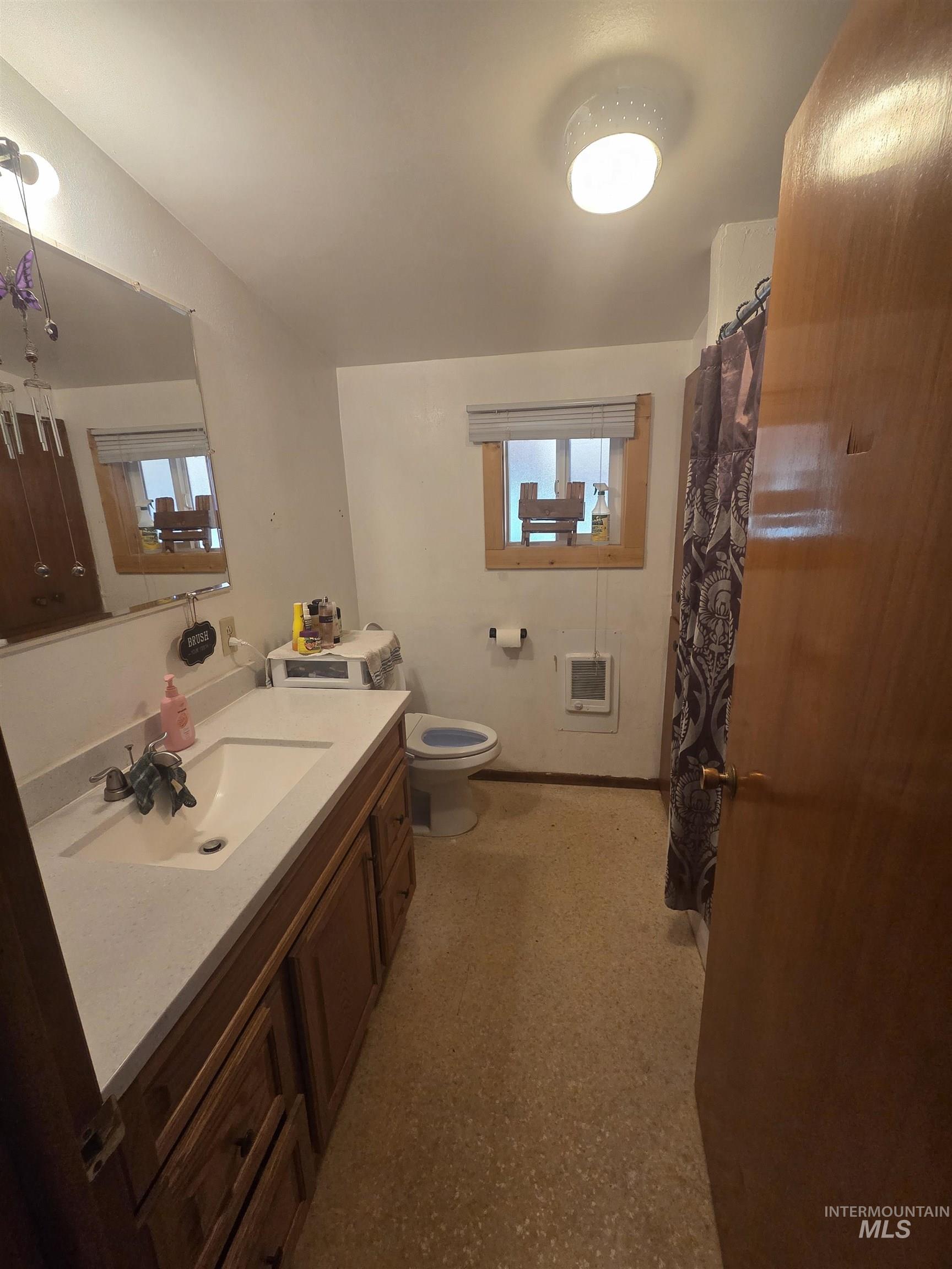 Full bath featuring vanity, a shower with shower curtain, and heating unit