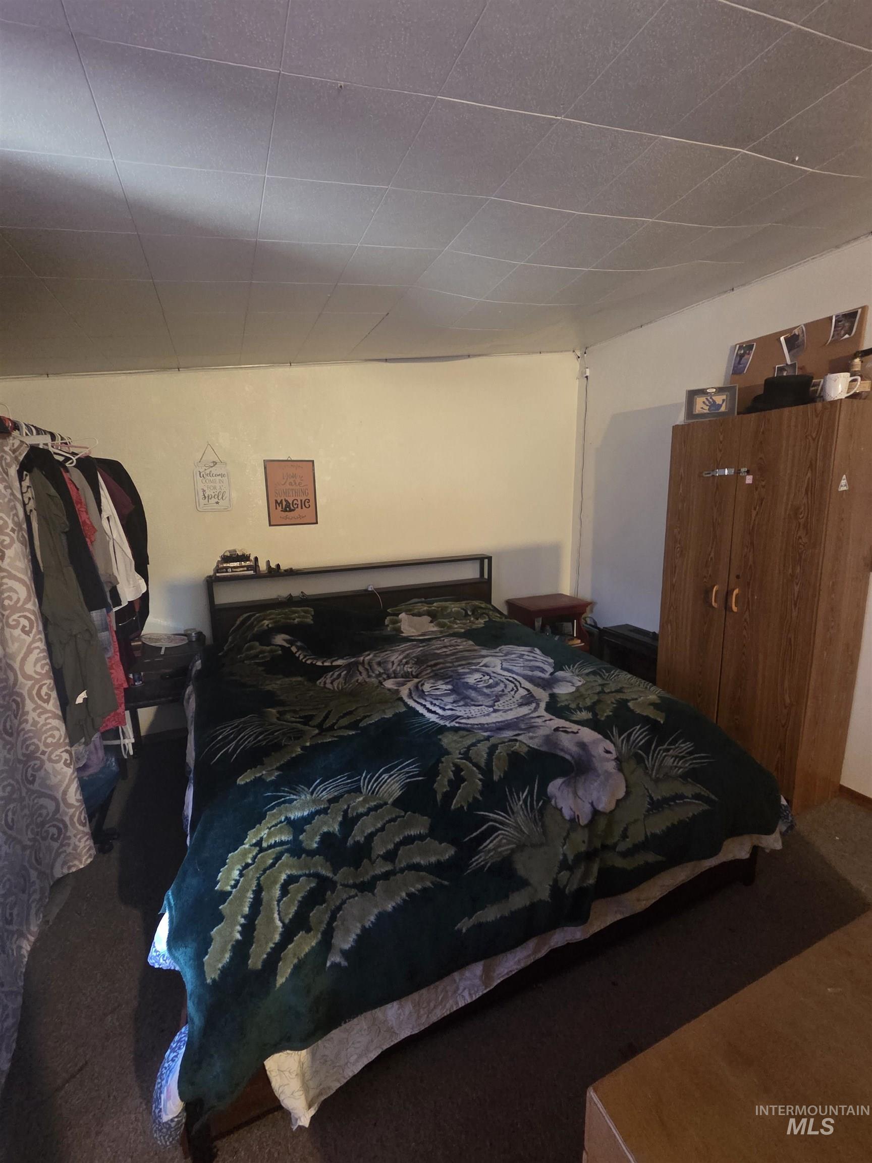 Carpeted bedroom with a drop ceiling