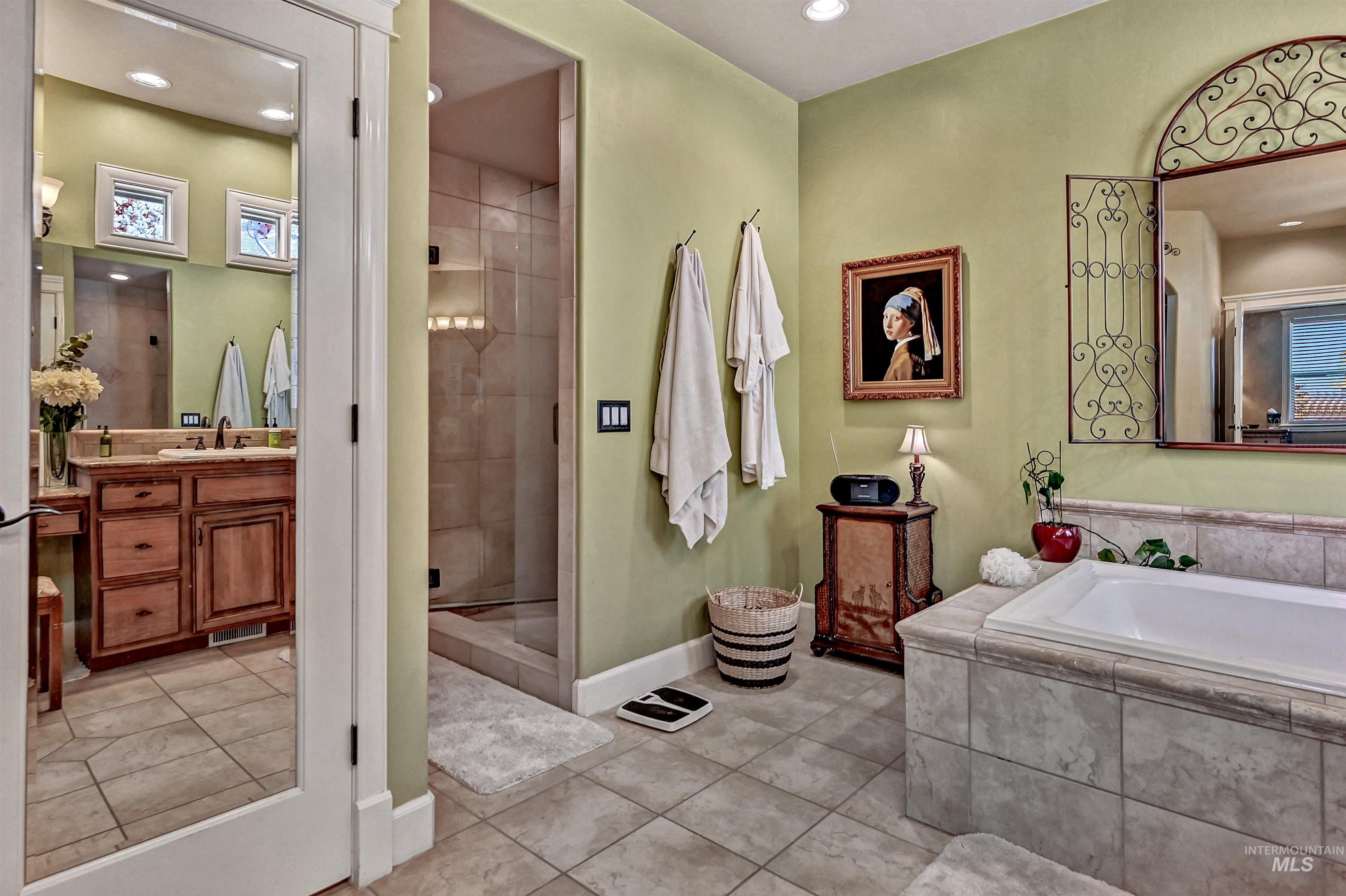 Bathroom with a stall shower, light tile patterned floors, vanity, a garden tub, and recessed lighting