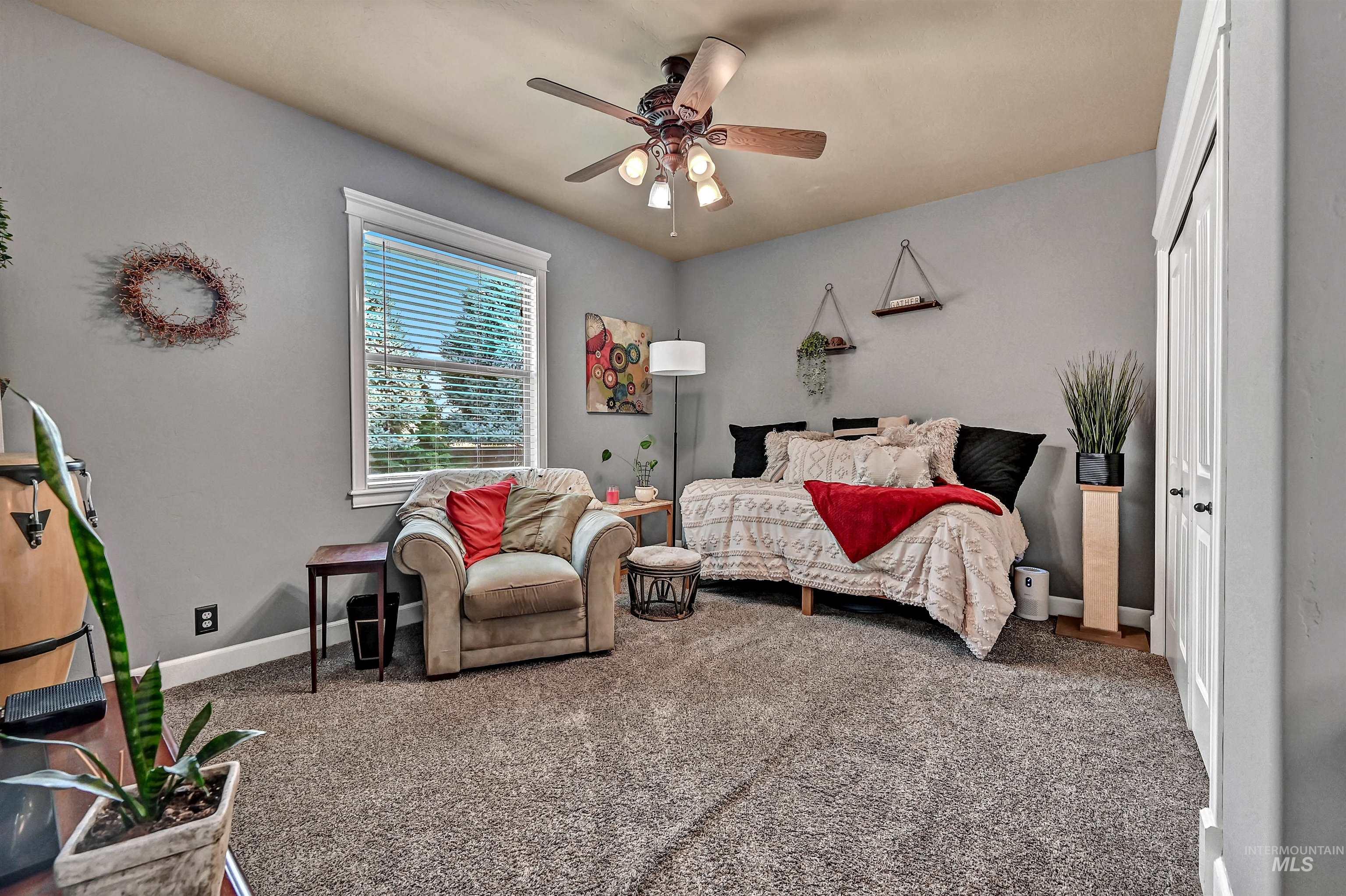 Carpeted bedroom with a ceiling fan and a closet