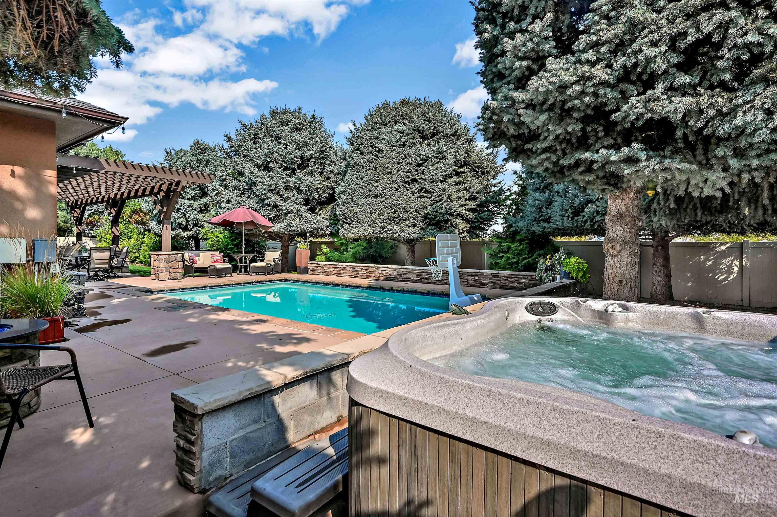 View of pool with a pergola, a patio, and a hot tub