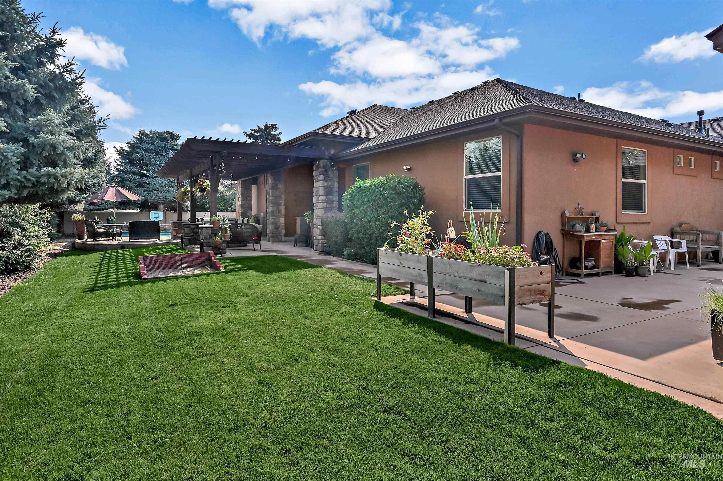Rear view of property featuring a patio area, a yard, stucco siding, a shingled roof, and a pergola