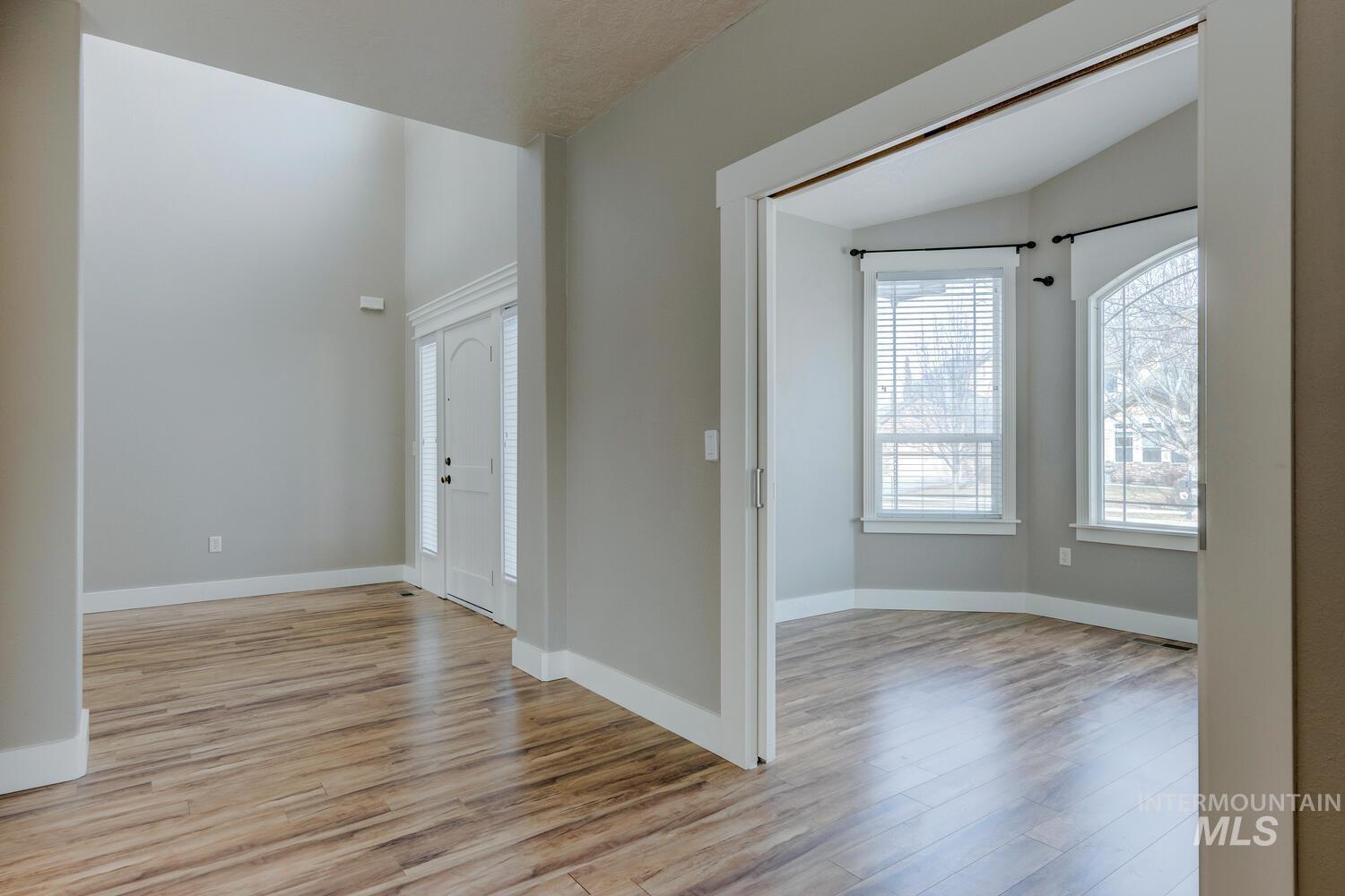 Spare room featuring light wood-type flooring and vaulted ceiling
