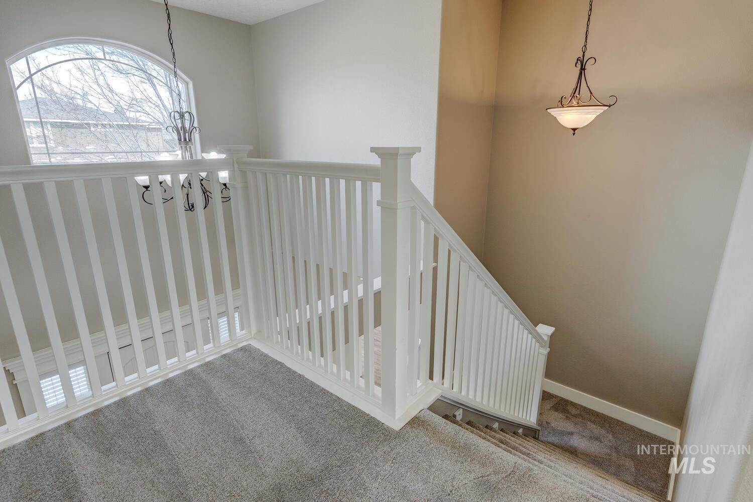 Staircase featuring carpet flooring and a chandelier