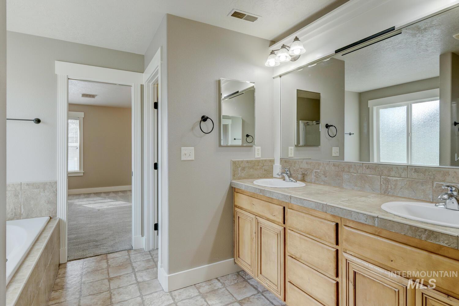 Bathroom with double vanity and a garden tub