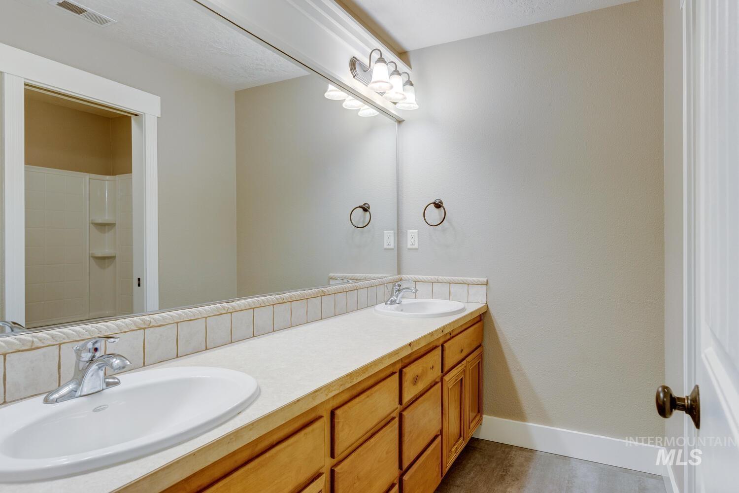 Bathroom with double vanity and a shower