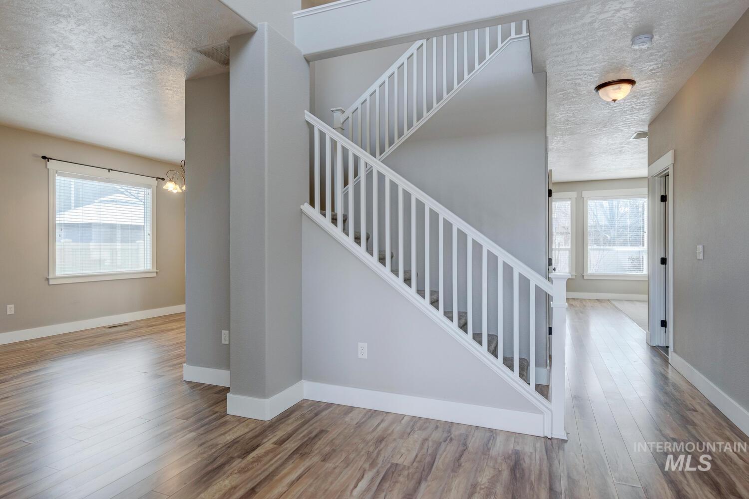 Staircase with a textured ceiling and wood finished floors