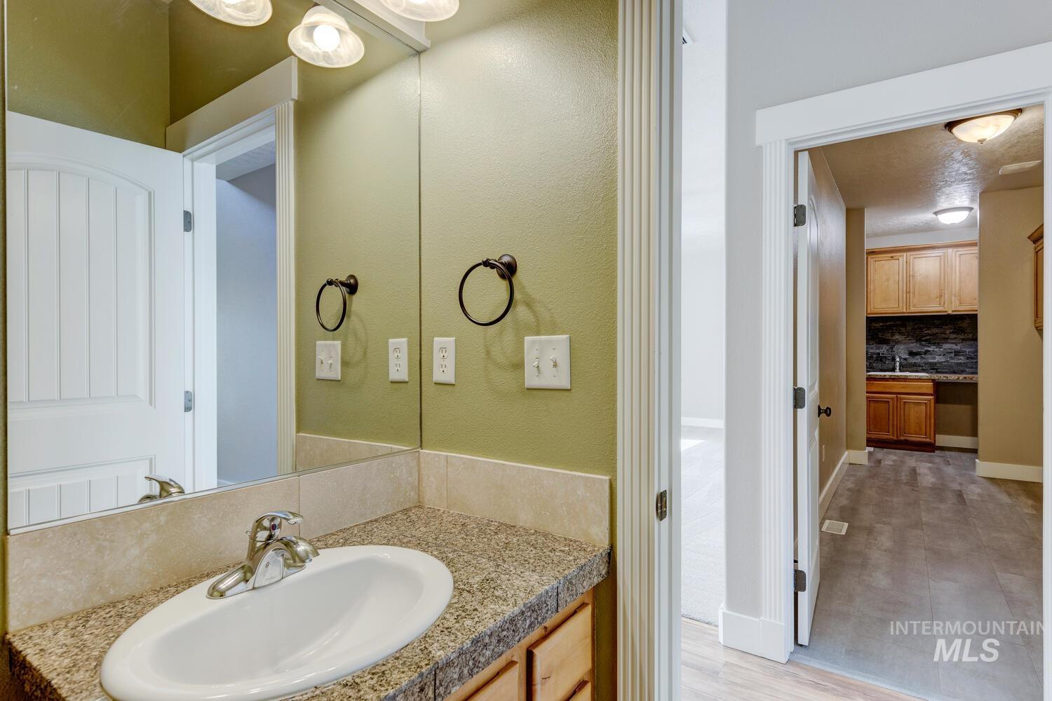 Bathroom with vanity, tasteful backsplash, and a textured wall