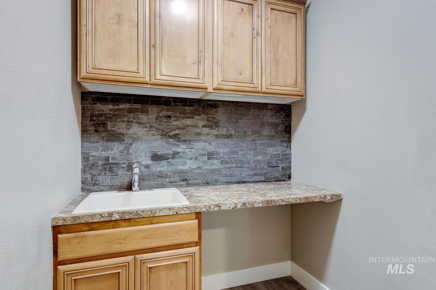 Kitchen featuring backsplash, light countertops, and light brown cabinets