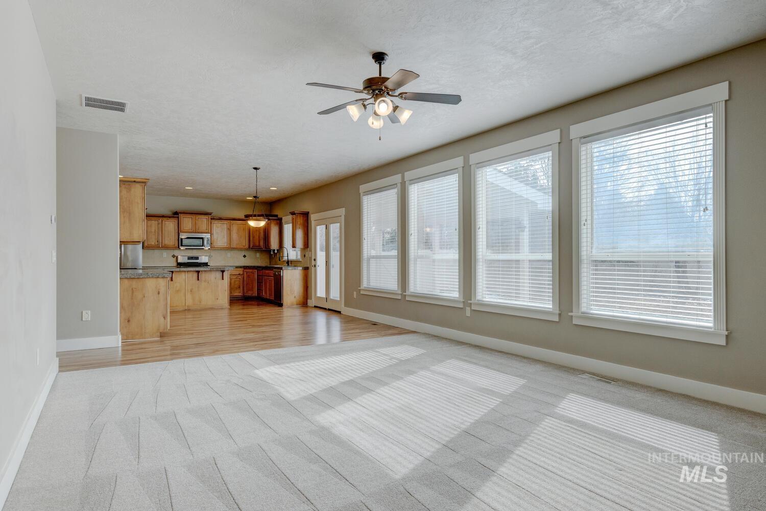 Unfurnished living room featuring ceiling fan and light wood-style flooring