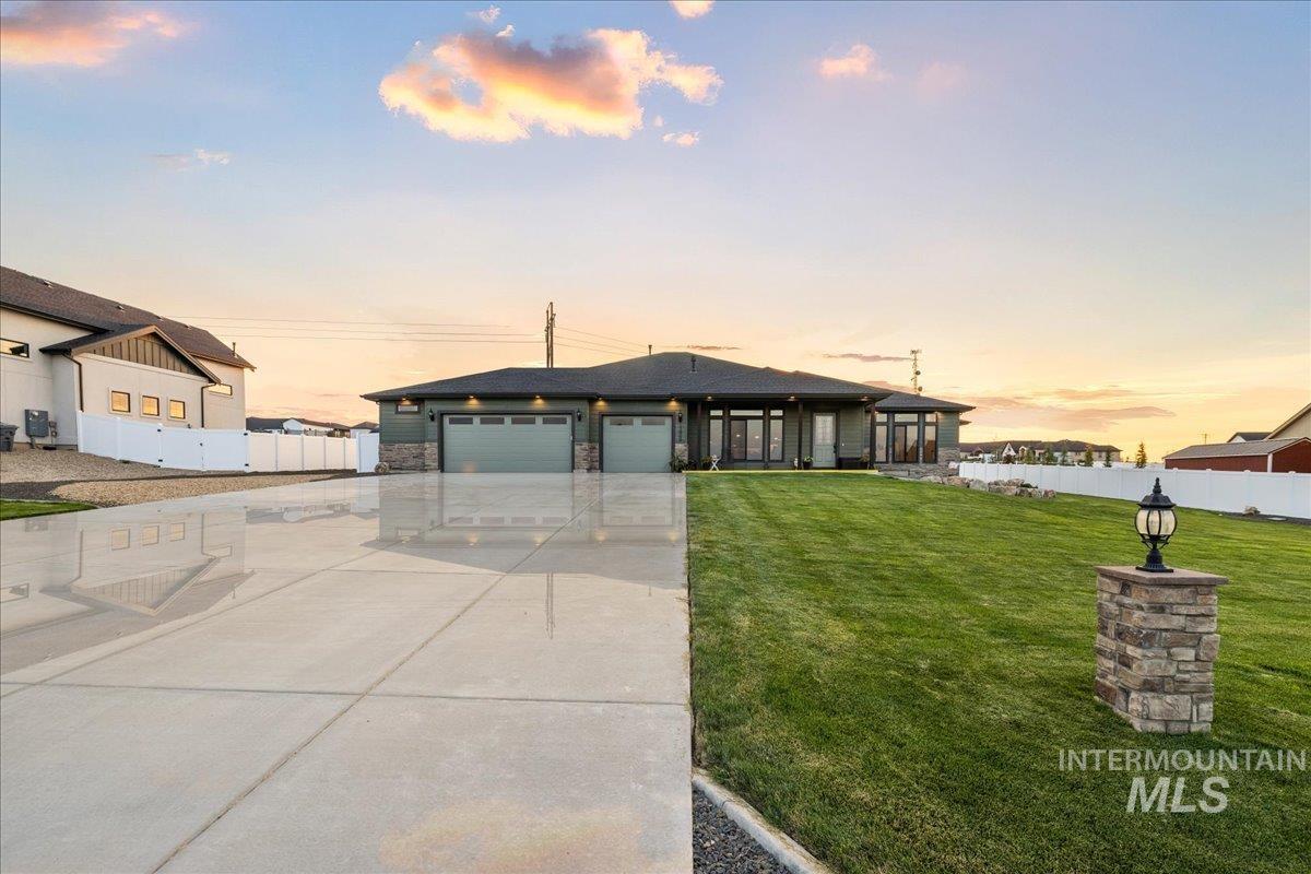 View of front of property with concrete driveway, a garage, and stone siding