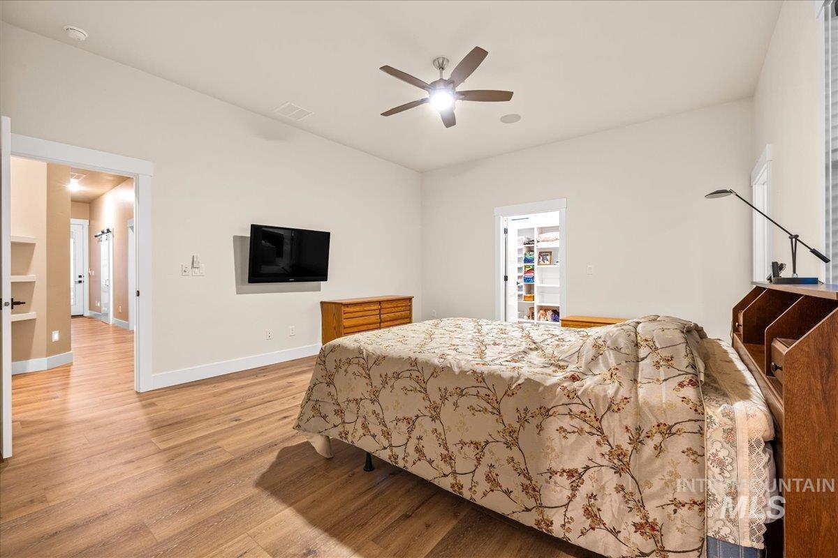 Bedroom with light wood-style floors and a ceiling fan