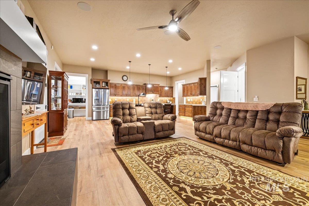 Living area featuring light wood-type flooring, ceiling fan, and recessed lighting