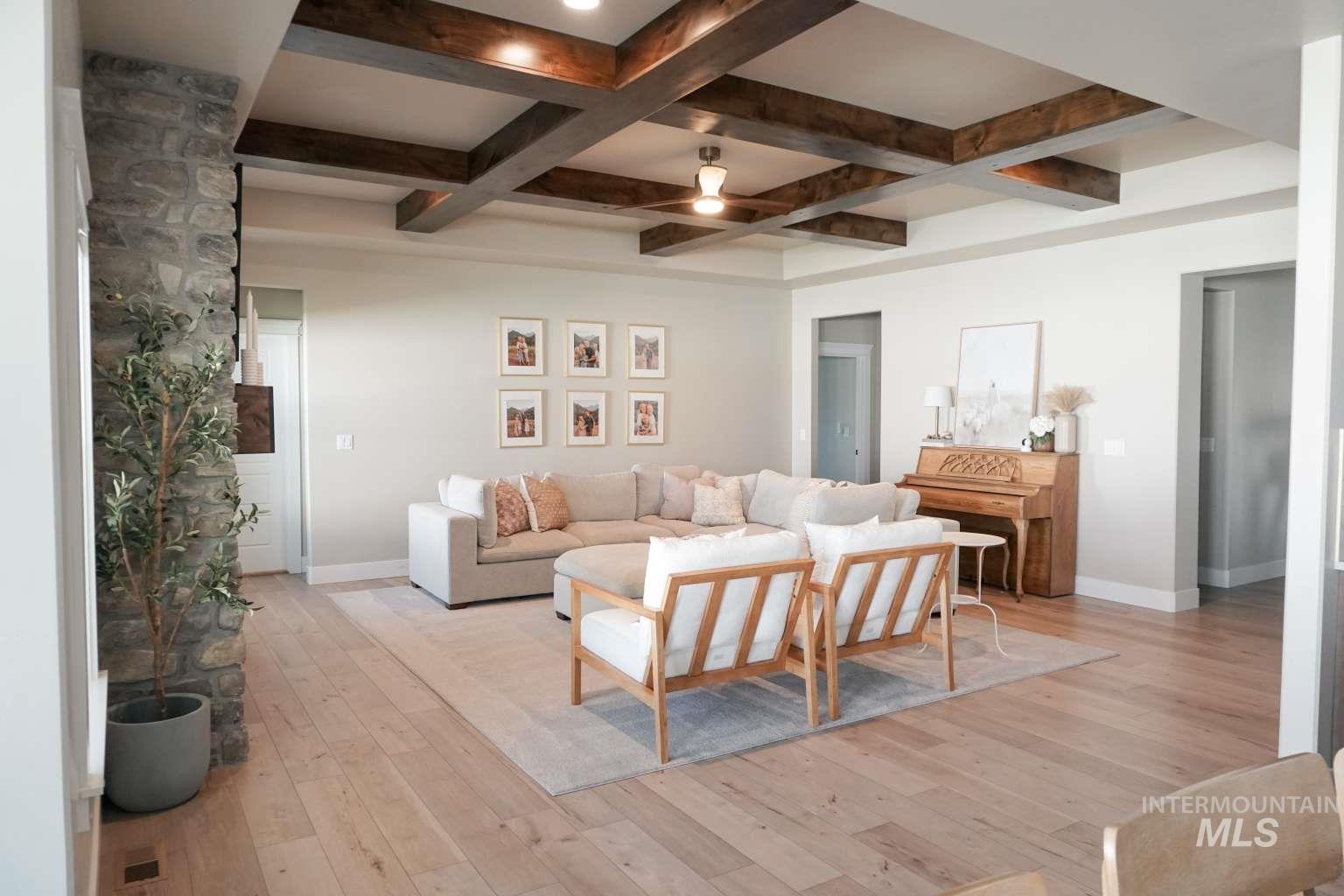 Living room featuring light wood-style floors, beam ceiling, and coffered ceiling