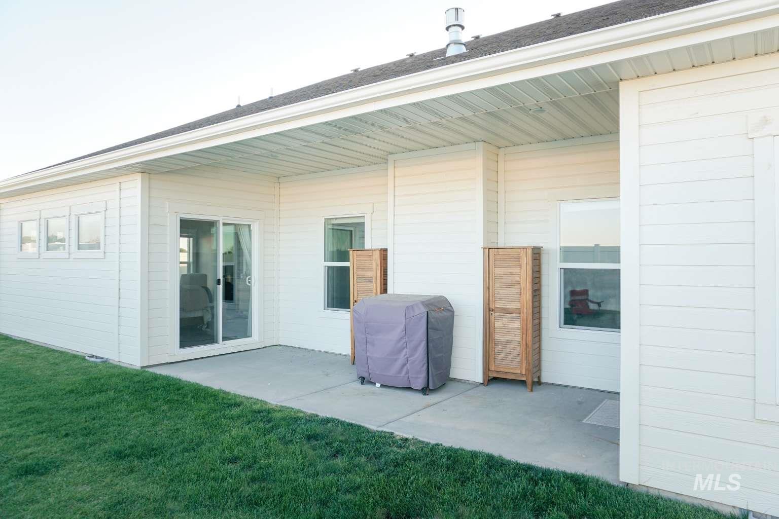 Back of property with a patio and a lawn