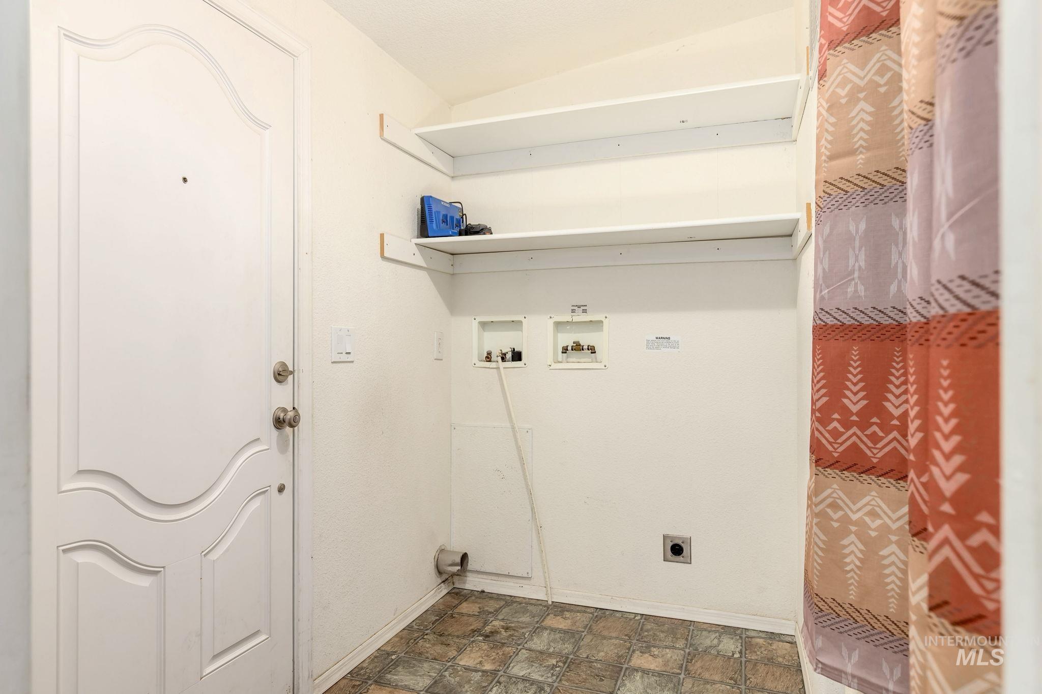 Washroom with stone finish floors, electric dryer hookup, and washer hookup