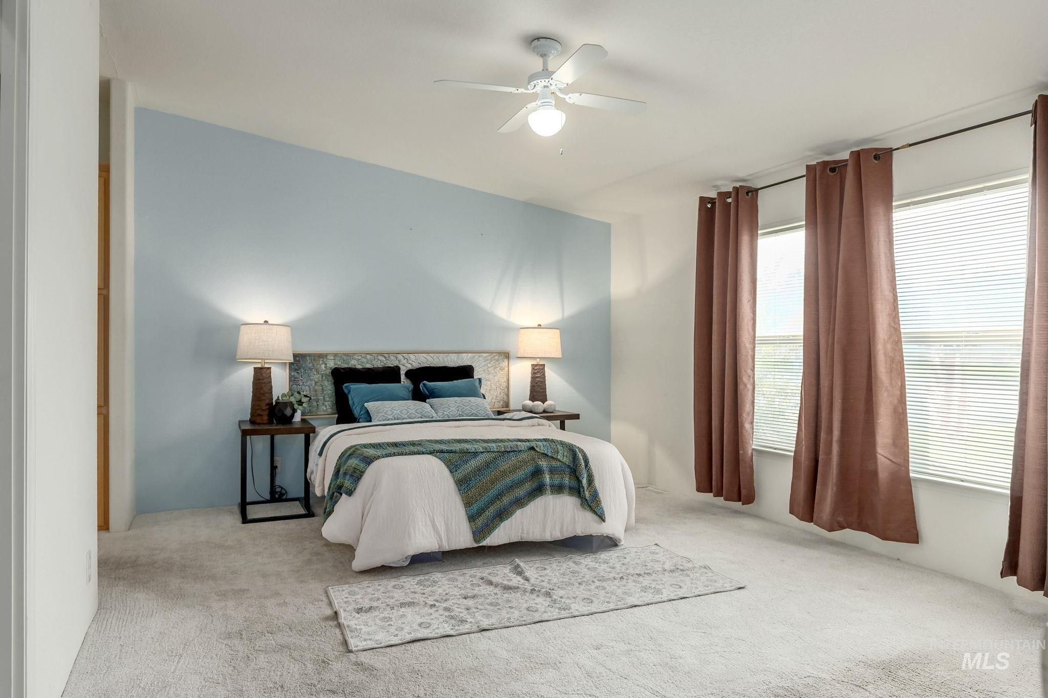 Carpeted bedroom featuring a ceiling fan