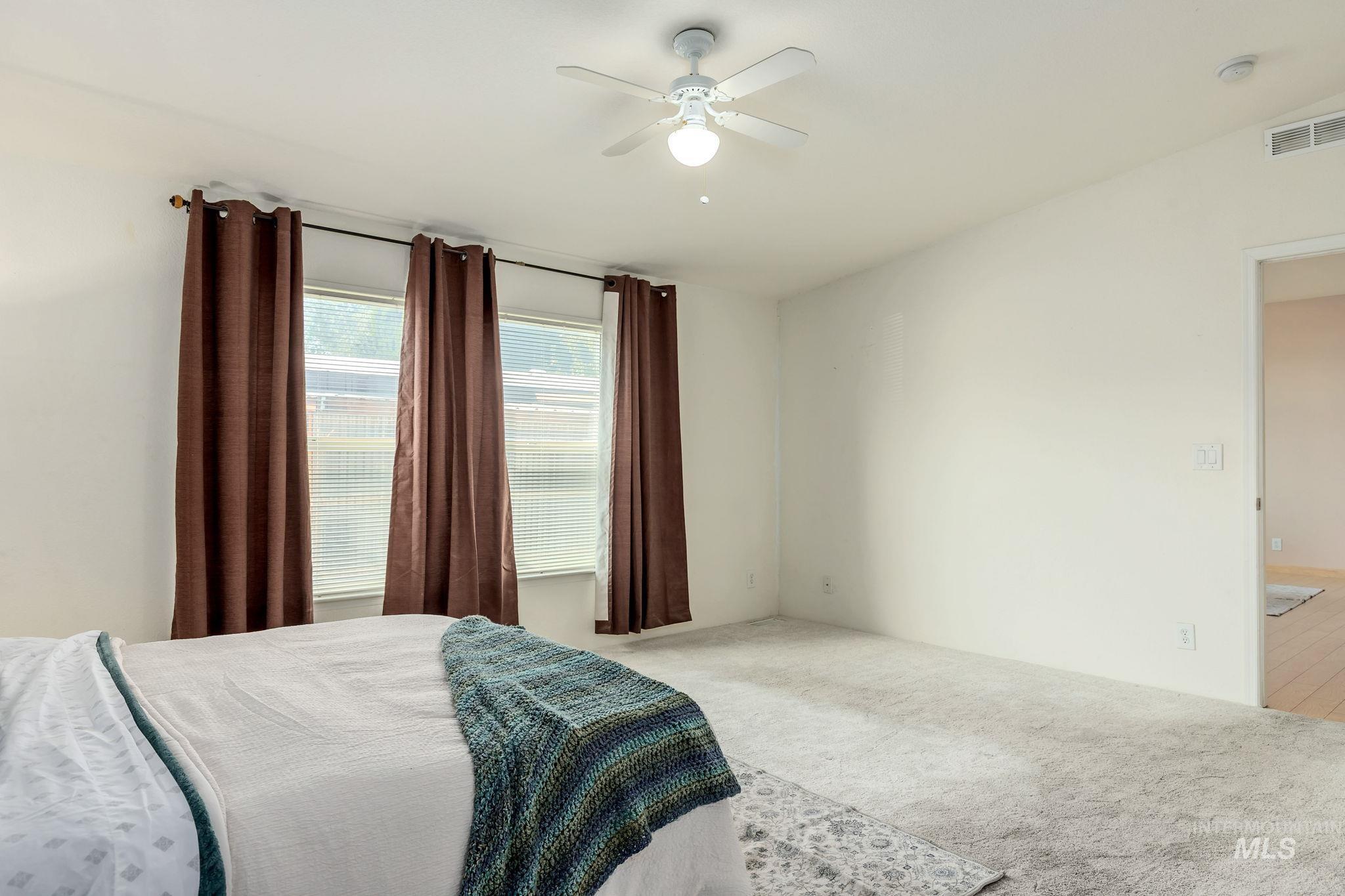 Carpeted bedroom featuring a ceiling fan