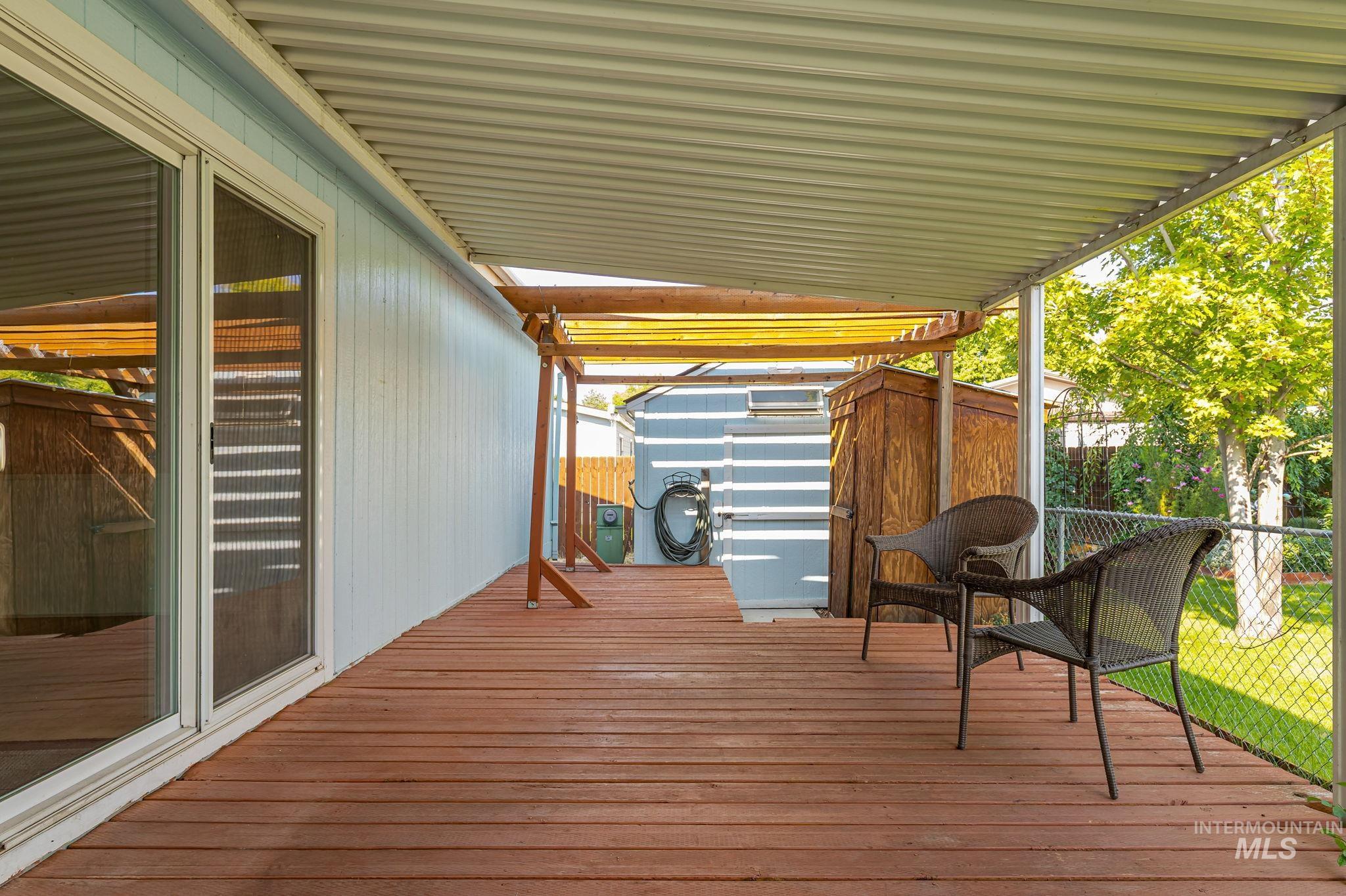 Wooden deck featuring a storage unit