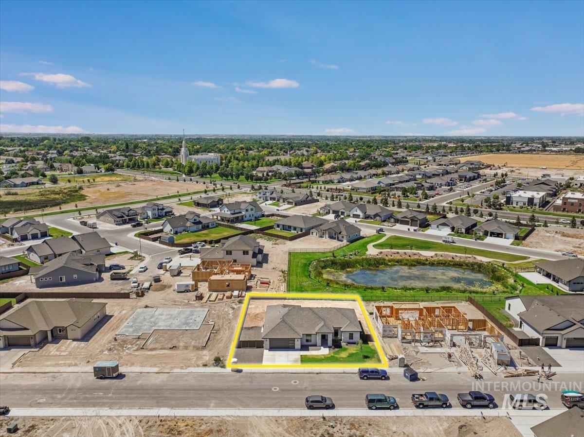 Aerial perspective of suburban area featuring property boundaries highlighted and a nearby body of water