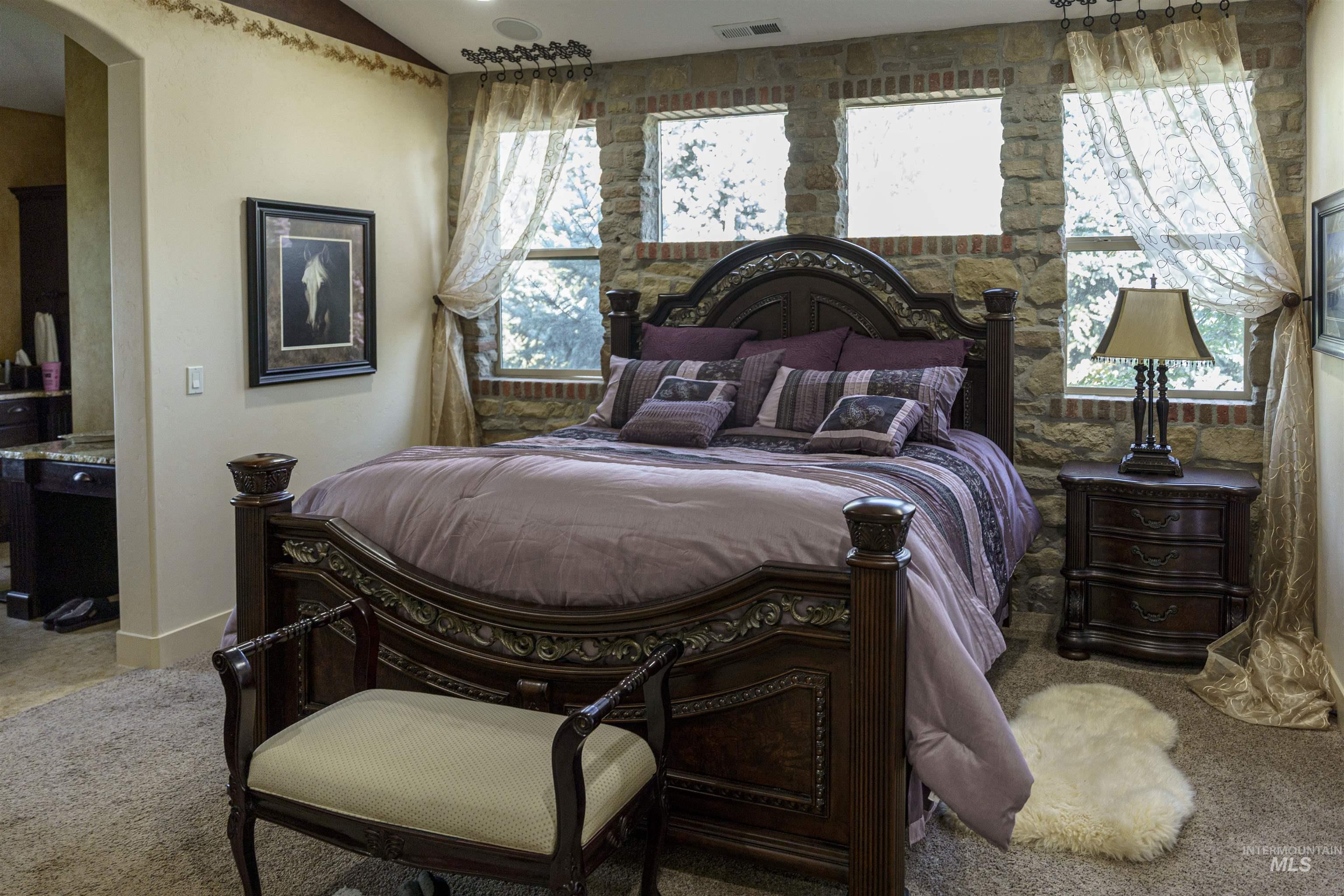 Bedroom featuring light carpet and arched walkways