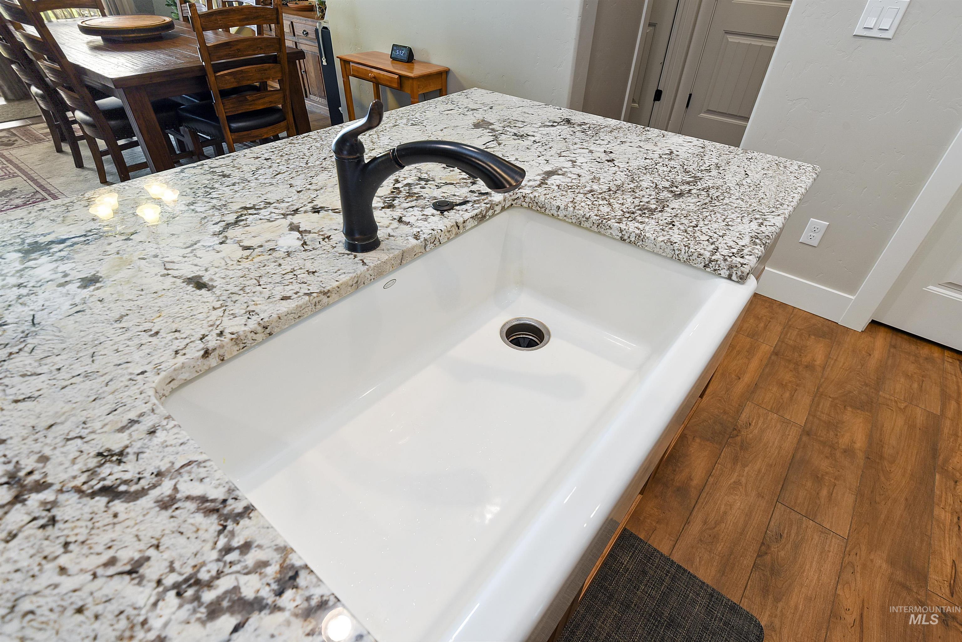 Detailed view of light stone countertops and wood finished floors