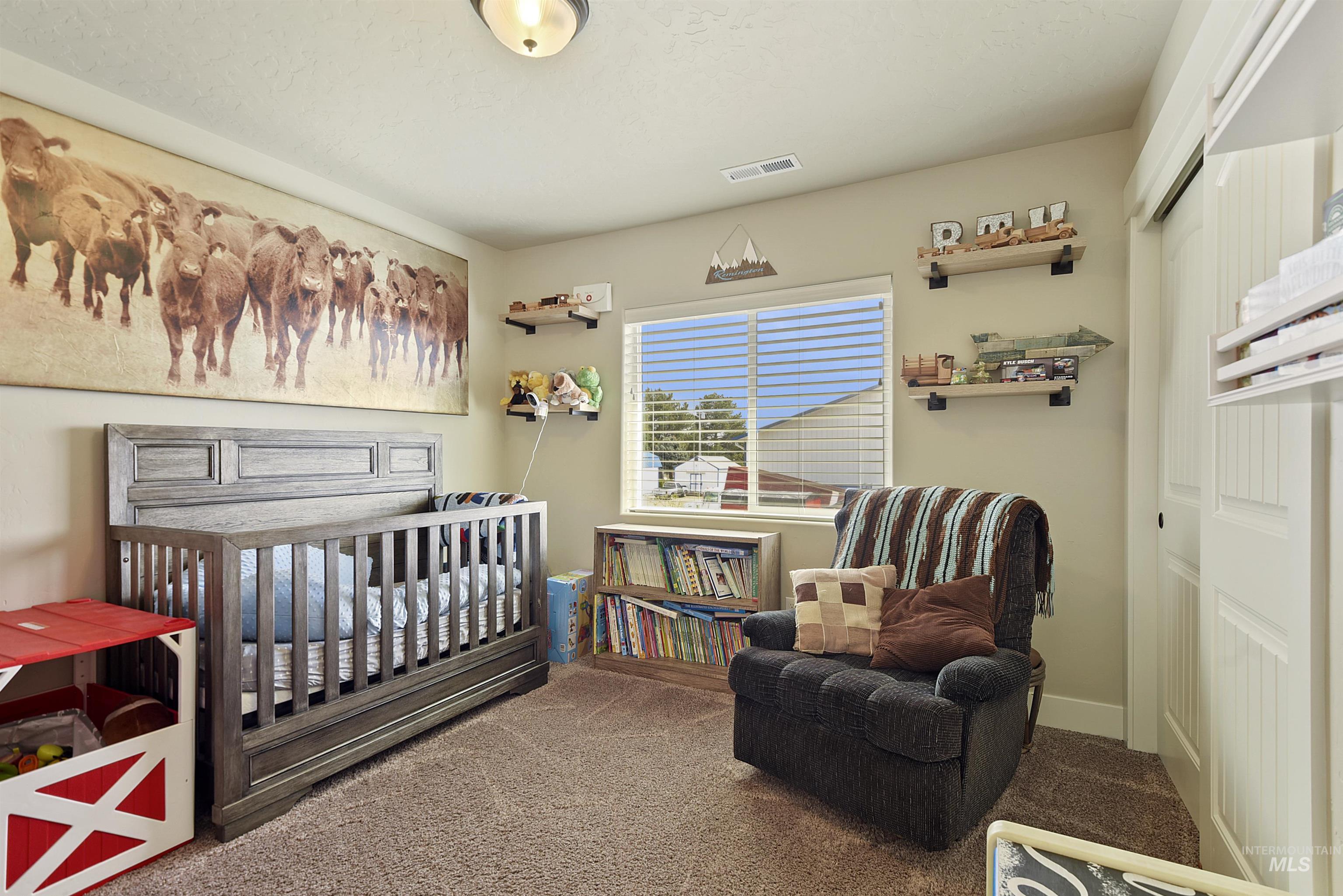 Carpeted bedroom with a nursery area and a closet