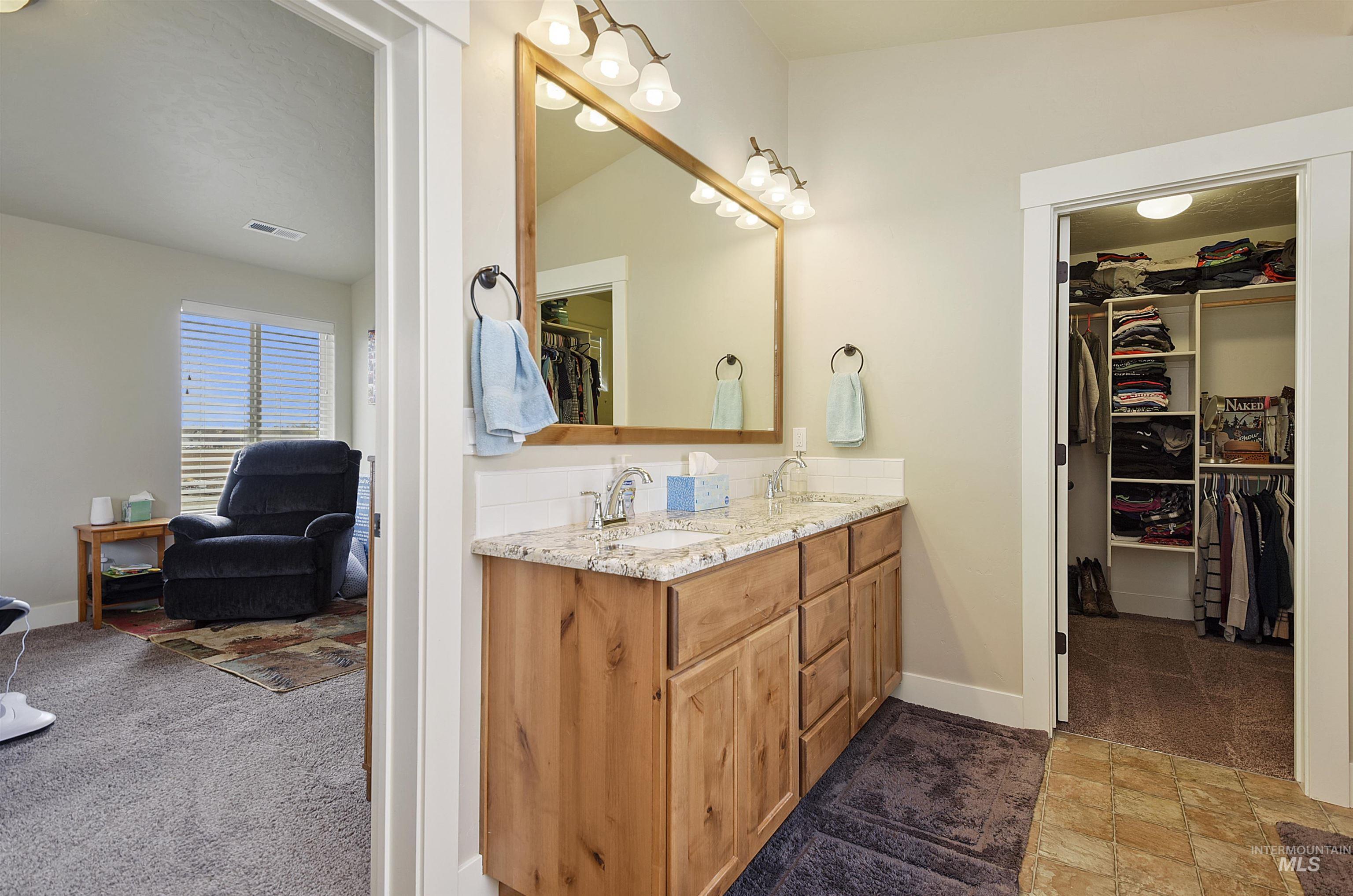 Bathroom with double vanity and a spacious closet