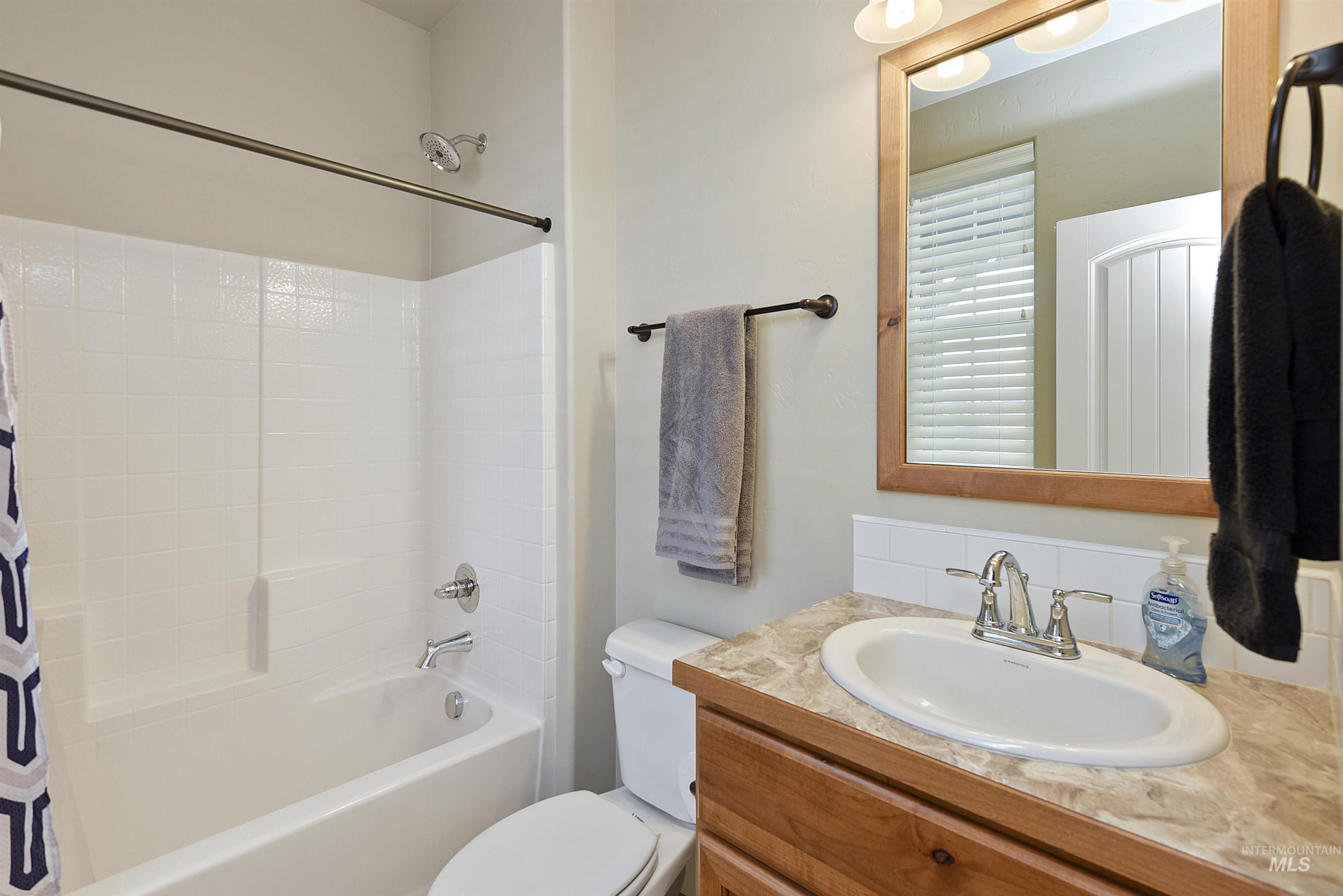 Bathroom with shower / bathtub combination with curtain and vanity