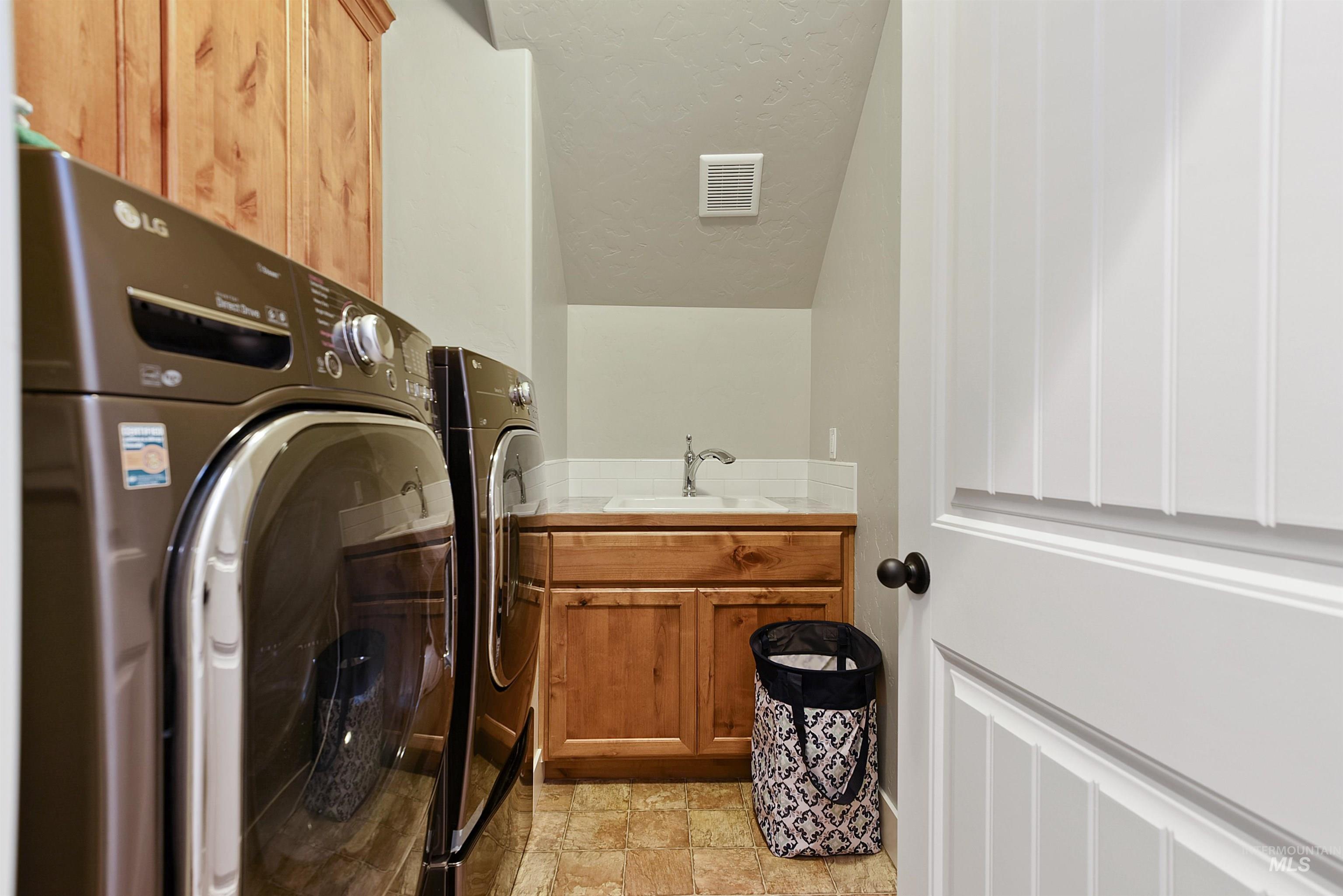 Laundry area with cabinet space, washer and dryer, and a textured ceiling