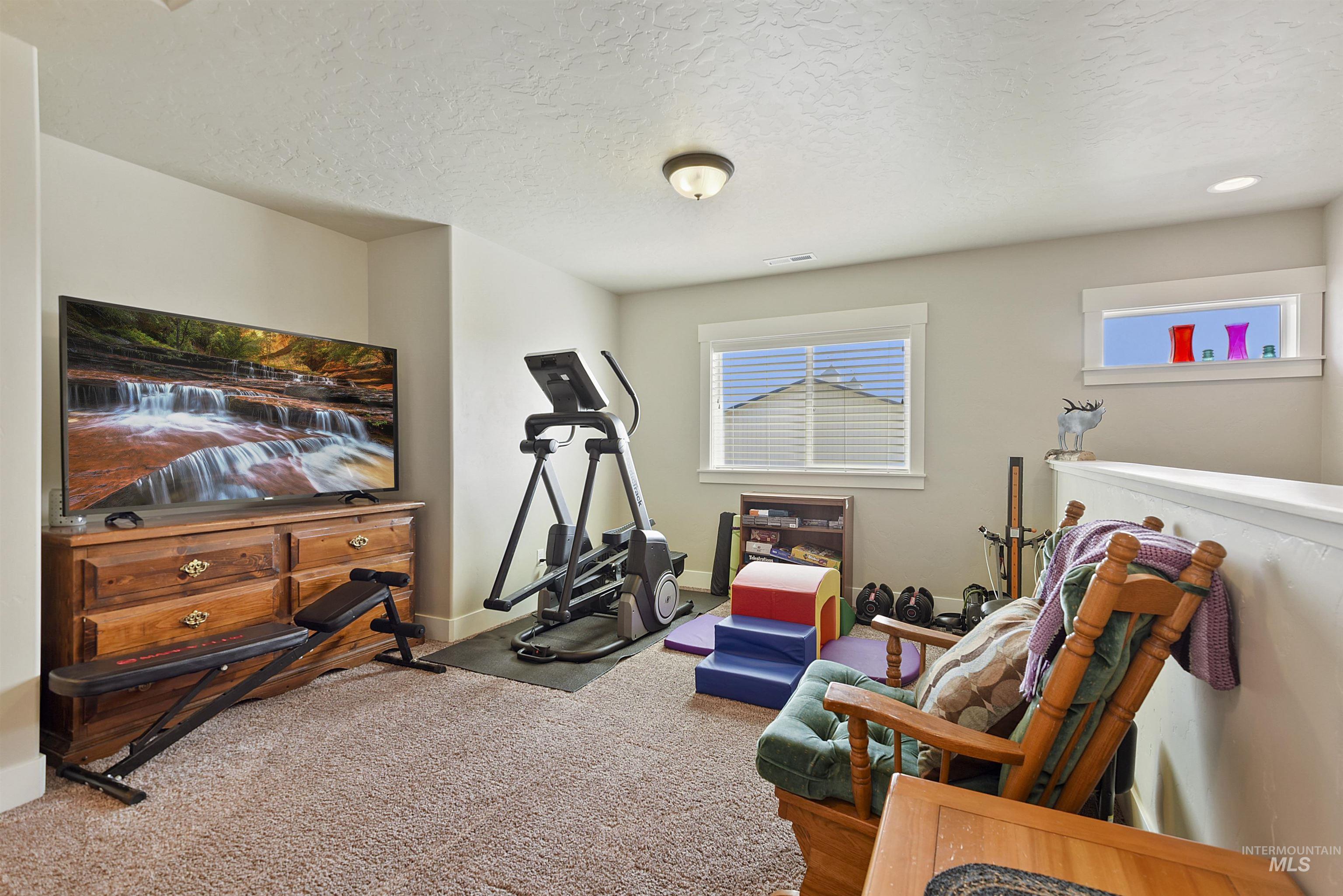 Workout room featuring a textured ceiling and carpet floors
