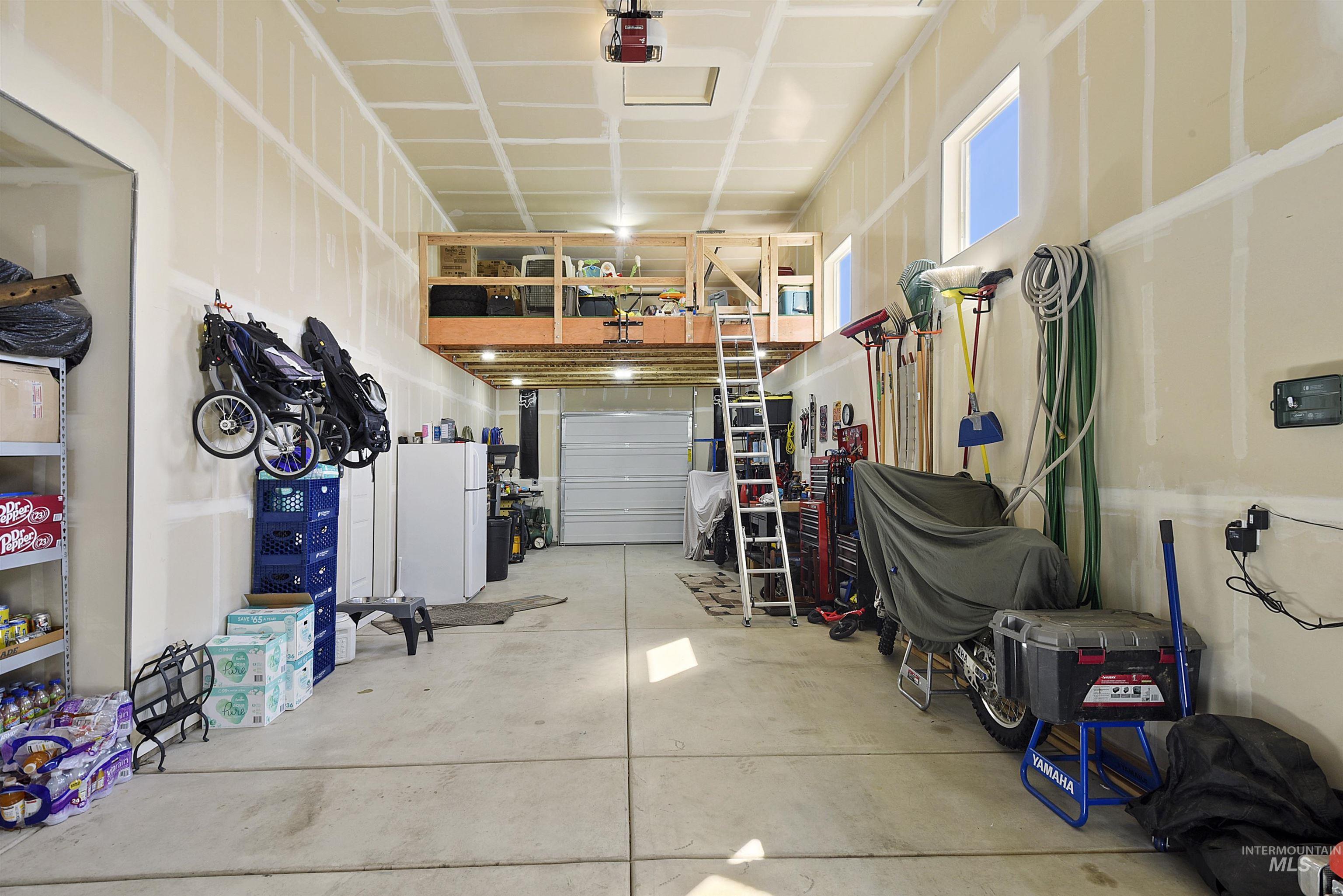 Garage with freestanding refrigerator and a garage door opener