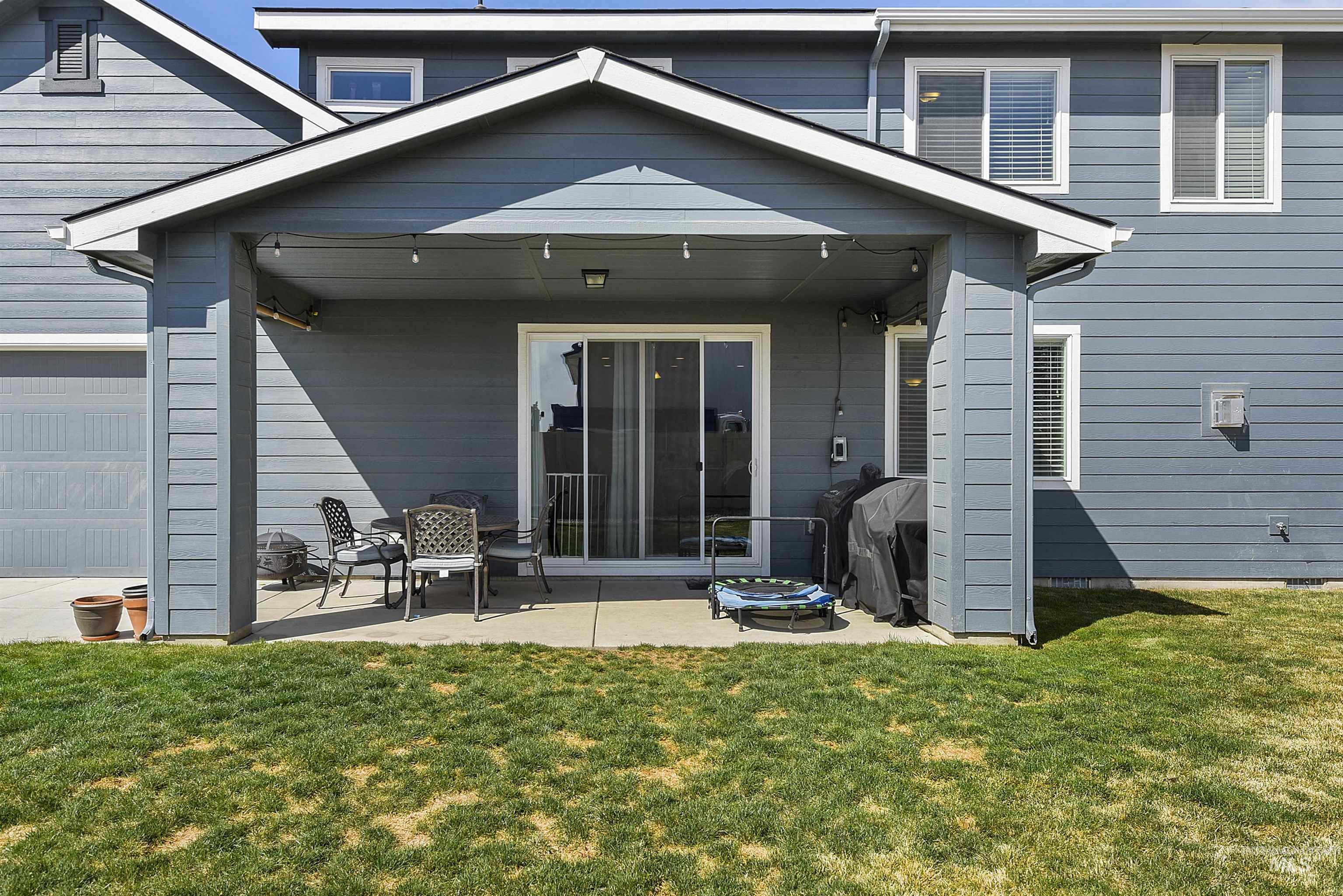 Rear view of house with a yard and a patio